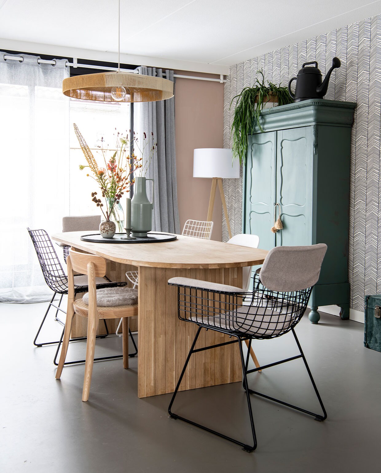 Gordijnen Karwei, muurkleur Zeester van Flexa, staande lamp Zuiver, meisjeskast van schoonmoeder in Histor-kleur Frivool, behang Herringbone van Ferm Living. Gieter Karwei en plantenpot op kast Dassie. Hanglamp, grote vaas en stoelen HKliving, tafel Woood, kleine vaas Sissy-Boy,kaarsenstandaard Branded, kaars Rustik. Gietvloer Evolve.