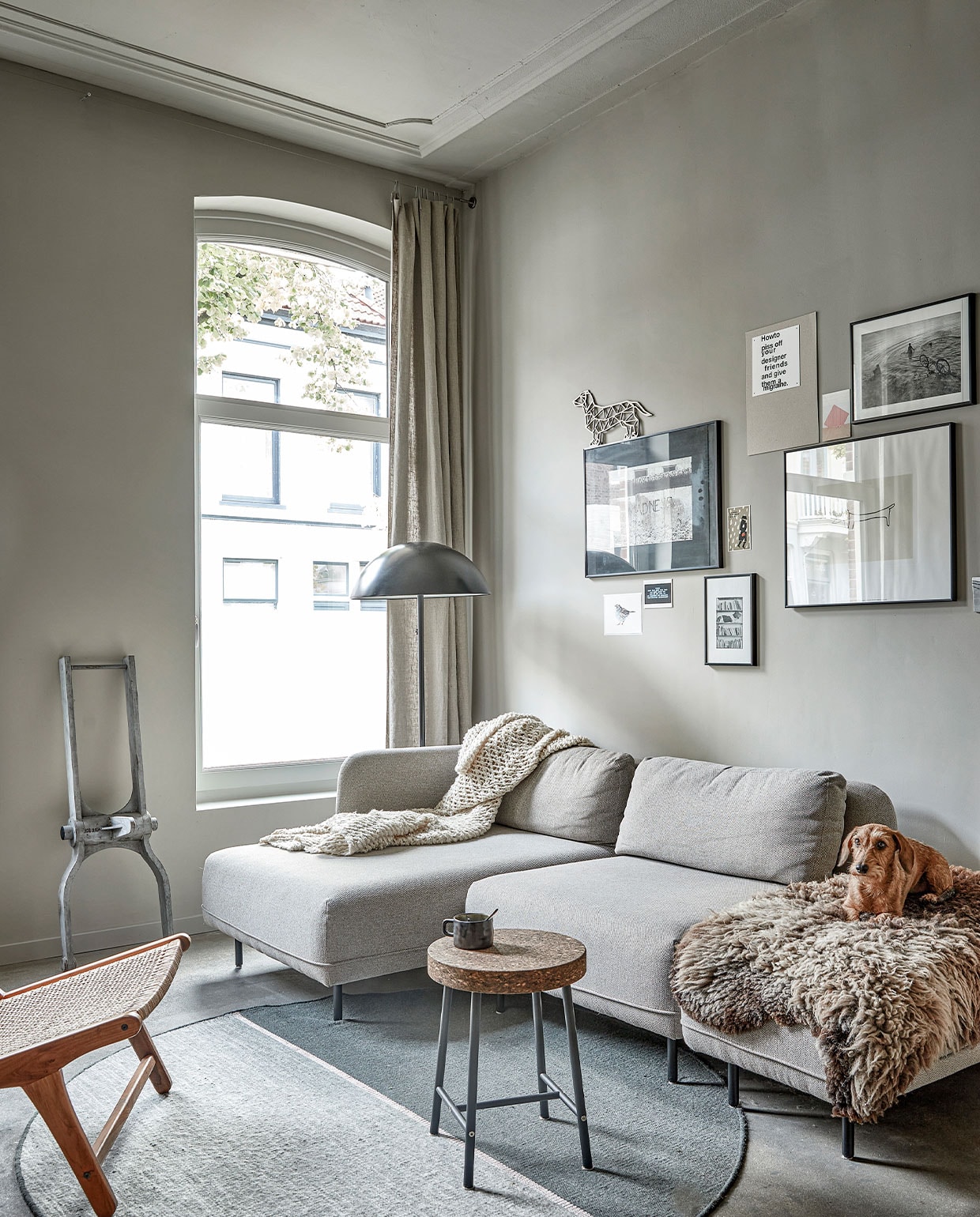 Zandcementen dekvloer met 2-componenten hoogglanscoating. Bank Ellis Sofacompany. Plaid en schapenvacht gekregen. Vloerkleed Magnetize Linie Design. Kruk Sinnerlig en vloerlamp Ikea. Stoel CHR01 Zara Home. Het ornament tegen de muur is een houten mal van ontwerper Faas van Dijk. De grote foto aan de muur is gemaakt door Mees’ vader. Print musje OpTekening.