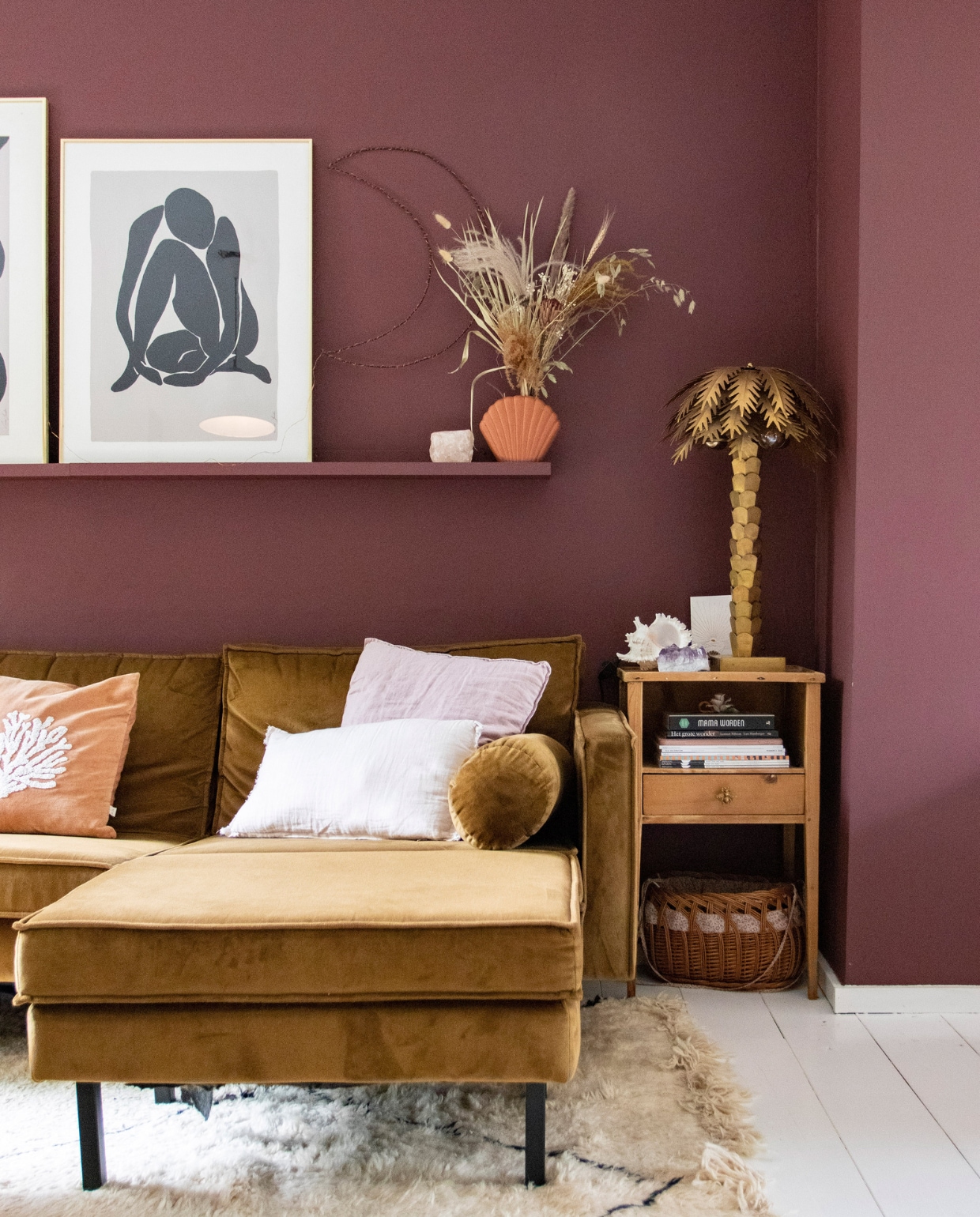 Muurverf Merlot Mania no. 123 Powderbox van Vestingh. Bank Rodeo van BePureHome, linnen kussenhoes H&amp;M Home, rode kussenhoes met schelp À La, koraalkleurige kussenhoes Leen Bakker, vloerkleed Beni Ouarain Outlet. Wandplank Ikea, maan zelfgemaakt, schelp Fonq, bloemen Happy Circle, palmboom HKliving, waxinelichthouder The Spirit Junkies, bijzettafel en mand vintage. Overig onbekend