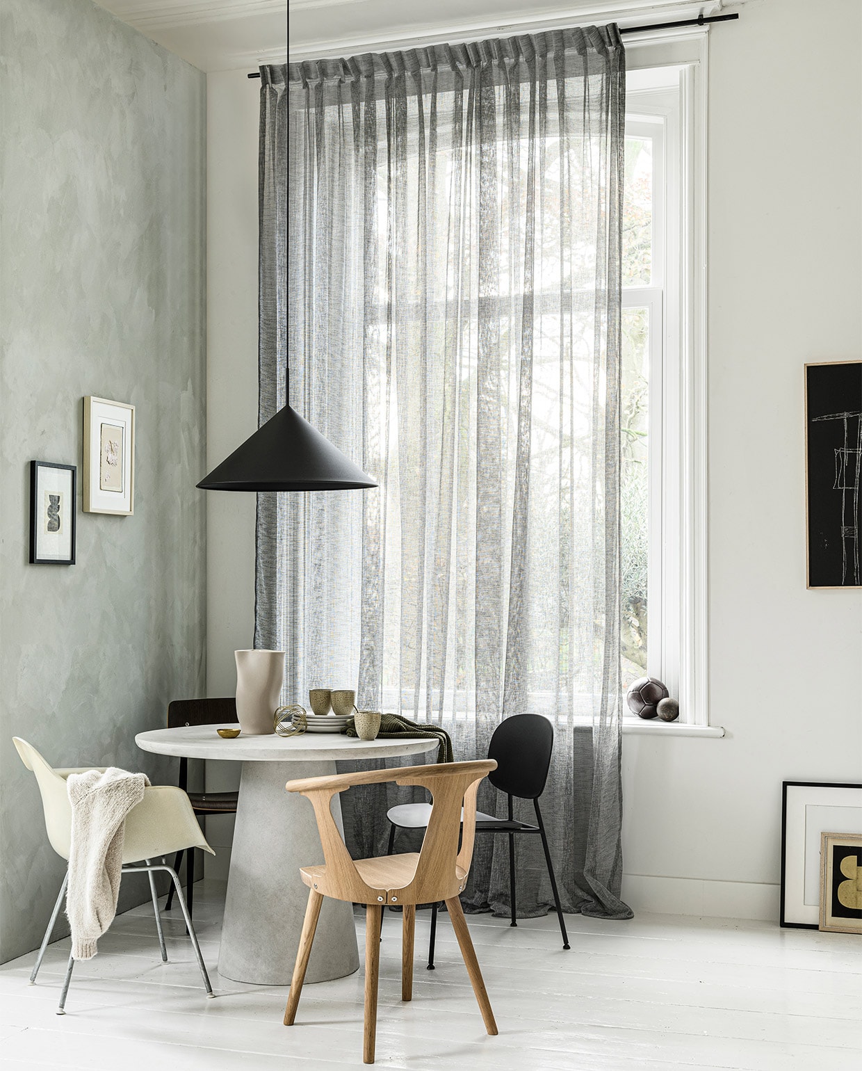 Gordijn op maat in stof Weave kleur 2712, per meter € 27,99 uit vtwonen collectie. M.m.v. basiclabel (betonlook tafel Damon), demachinekamer.nl (Eames-stoel), loods5 (stoel In Between van &amp;Tradition, zwarte stoel rechts van Menu, zwarte stoel links Result van Hay), hkliving (lamp, mokken, zwart kunstwerk), EawyArt via etsy.nl (kunstwerk in zwarte lijst), wonderwallstudios.com (kunstwerk in lichte lijst), hm.com (theedoek), vestingh.nl (kalkverf Smoking Glass). Overig privébezit.