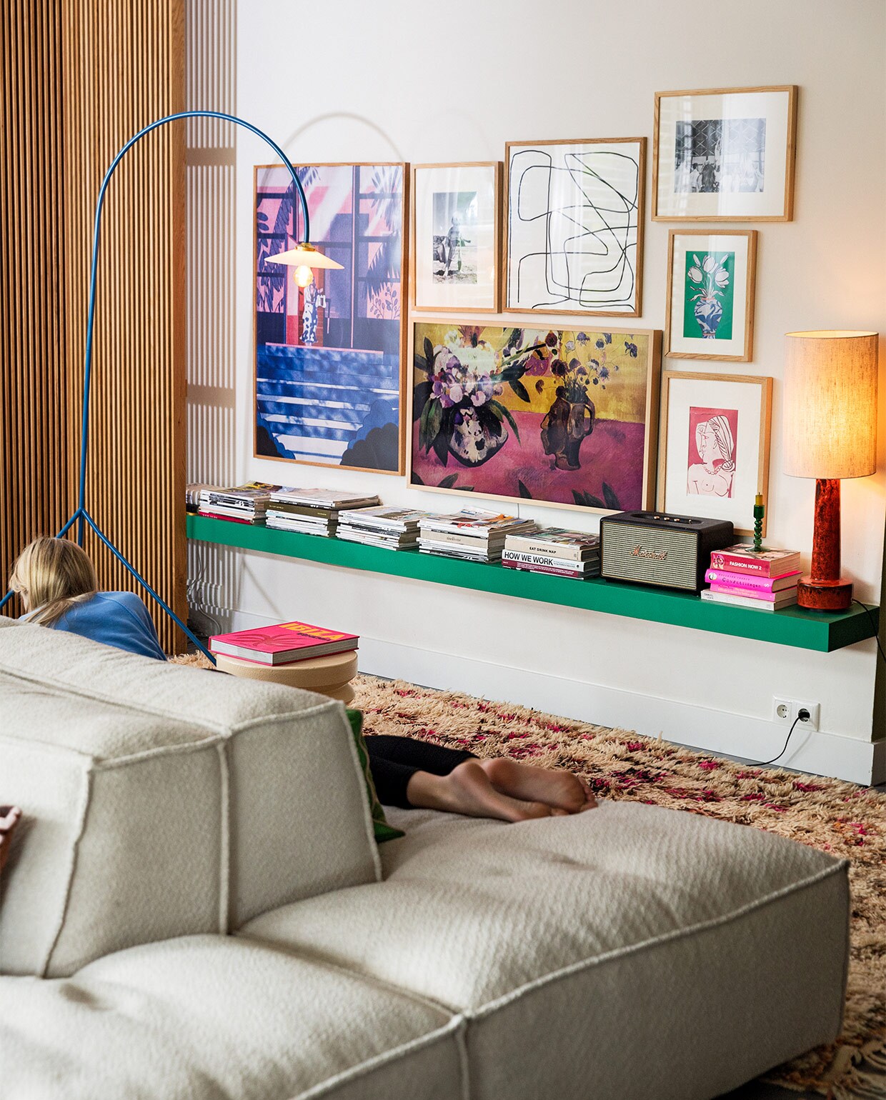 Houten hoeklatten op maat gemaakt door meubelmaker Peter Vocking. Blauwe staande lamp Valerie Objects. Televisie Samsung the Frame Wood. Muziekbox Marshall. Kleed vintage berber via Etsy. Kunst eigen verzameling. Elementenbank Square van Easy Sofa. Overig herkomst onbekend.