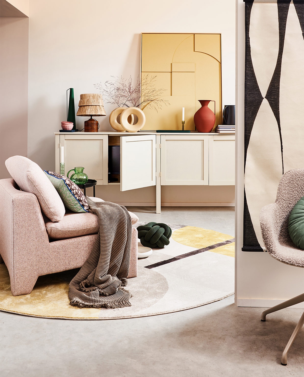 Kast op maat gemaakt, prijs op aanvraag (combitex). Bruin gebloemd kussen by Doris voor HKliving op fauteuil, 35×60 cm € 37,95, boucléstoffen retro loungefauteuil € 949,-, zwart-wit abstracte wandkaart, 97×157 cm (bxh) € 49,95, groene glazen karaf, 16 cm (Ø) € 29,95, okergele en groene glazen kandelaars, per stuk € 17,95, zandkleurig reliëfpaneel ingelijst, 63×83 cm € 469,-, crèmekleurige ronde vazen van HKliving, per stuk € 34,95 (hkliving). Katoenen plaid 130×170 cm € 45,99 (zarahome.com). Vloerkleed Hilton, 240 cm (Ø) € 465,-, taupekleurige armstoel Albert Kuip Swivel € 269,-, tray € 49,- (zuiver). Groen kussen Knot van Design House Stockholm, 30 cm (Ø) € 115,90, zwarte kan van vtwonen € 18,-, bruine vaas van Pols Potten, onderdeel van set van 3 € 220,- (vtwonen.be). Tafellamp € 119,50 (maisonnl.com). Overig privébezit.