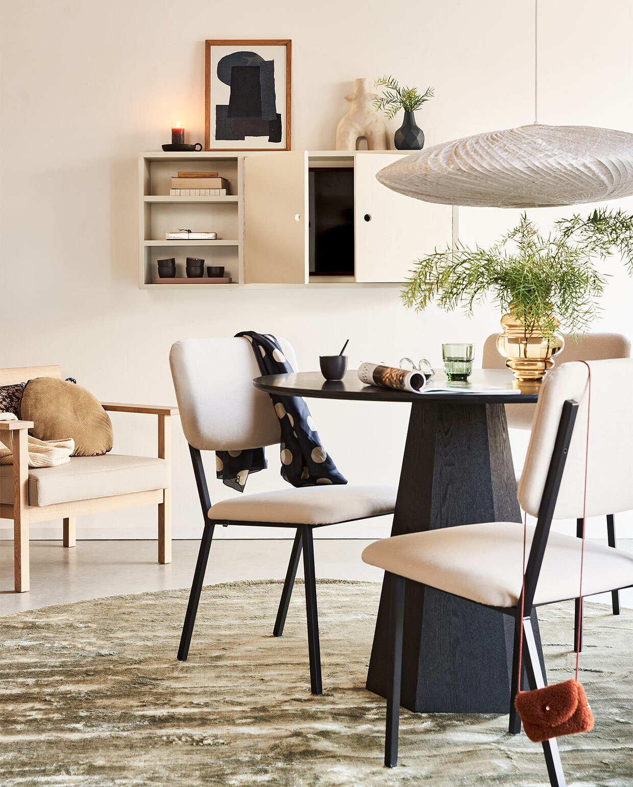 Wandkast in kleur Shaded White 201 van Farrow &amp; Ball, 122x20x53 cm (bxdxh), prijs op aanvraag (combitex). Televisie The Frame, 32 inch € 429,-, verwisselbare walnoten lijst The Frame € 129,- (samsung). Zwarte vaas € 35,-, paarse tray in de kast € 49,-, tafel Pilar, 100 cm (Ø) € 625,- (zuiver.nl). Zandkleurige ecomix gerecyclede vaas Twig van vtwonen, 29 cm (h) € 44,95, groen karpet van BePureHome, 250 cm (Ø) € 449,50, glazen vaas van Bloomingville, 24 cm € 35,99 (vtwonen.be). Stoffen kunstwerk met eikenhouten lijst € 69,- (sur-atelier). Eetkamerstoelen Co gestoffeerd met Olbia Sand 03, per stuk € 375,-, loungefauteuil Base, zitting gestoffeerd met Divina 3/224 van Kvadrat € 1100,- (studio-henk). Corduroy kussen, 40 cm (Ø) € 35,80, bruin kussen met print van by Doris voor HKliving, 60×35 cm€ 37,95, bamboe hanglamp € 495,-(hkliving). Overig privébezit.