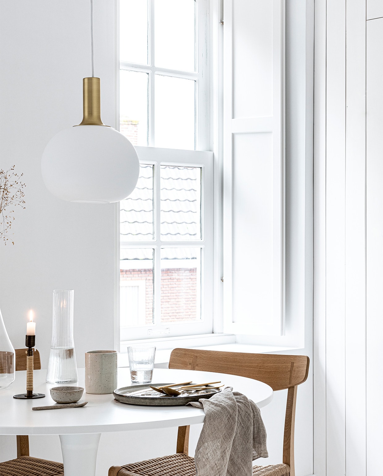 Art print van Gurilla, 50×70 cm € 79,-, eikenhouten frame, 50×70 cm € 69,- (theposterclub.com). Hanglamp Alton 25 van Nordlux € 69,95, groen dinerbord uit de Artisan collectie van Salt &amp; Pepper, Ø 26,5 cm € 9,95, gouden bestek van Amefa, 24-delig € 57,95, theedoek uit de vtwonen collectie, 60×60 cm € 12,95 (vtwonen.be). Witte ronde eettafel Docksta € 149,- (ikea). Eikenhouten eetkamerstoel met gevlochten zitting CH23 van Carl Hansen &amp; Søn € 860,- (coosdewitwonen). Messing kandelaar omwikkeld met rotan Duca € 69,- (menu.as). Glazen karaf met handvat € 22,99, drinkglas met ribbels € 2,99, kegelvormige glazen kan met ribbels € 12,99, beker aardewerk € 9,99 (zarahome.com). Overig privébezit.