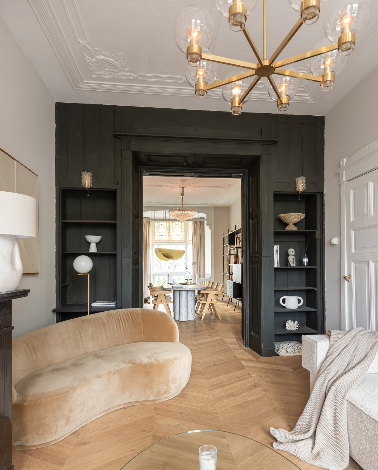 Fluwelen bank Sofa Company, staande lamp Flos, bank Flow Rotterdam, hanglamp Venini, lamp op schouw van Margreet van Schaijck, accessoires in kast van Maison Jolie, vintage en souvenirs, eettafel op maat gemaakt, eetkamerstoelen Aime Té Studio messing hanglamp Gervasoni. Overig onbekend.