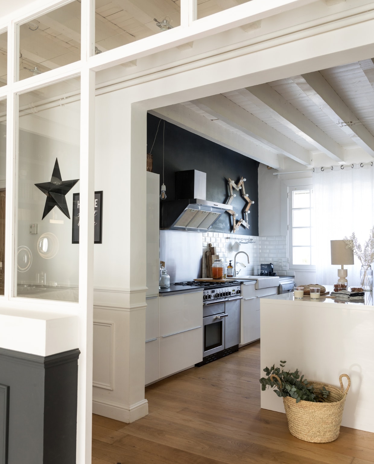 Zwarte ster House Doctor. Keuken, afzuigkap, gootsteen en kraan Ikea. Ster in de keuken zelf­gemaakt, vergelijkbare Sklum. Vergelijkbare items: tafellamp Casa Gitane, mand Kwantum. Overig vintage.