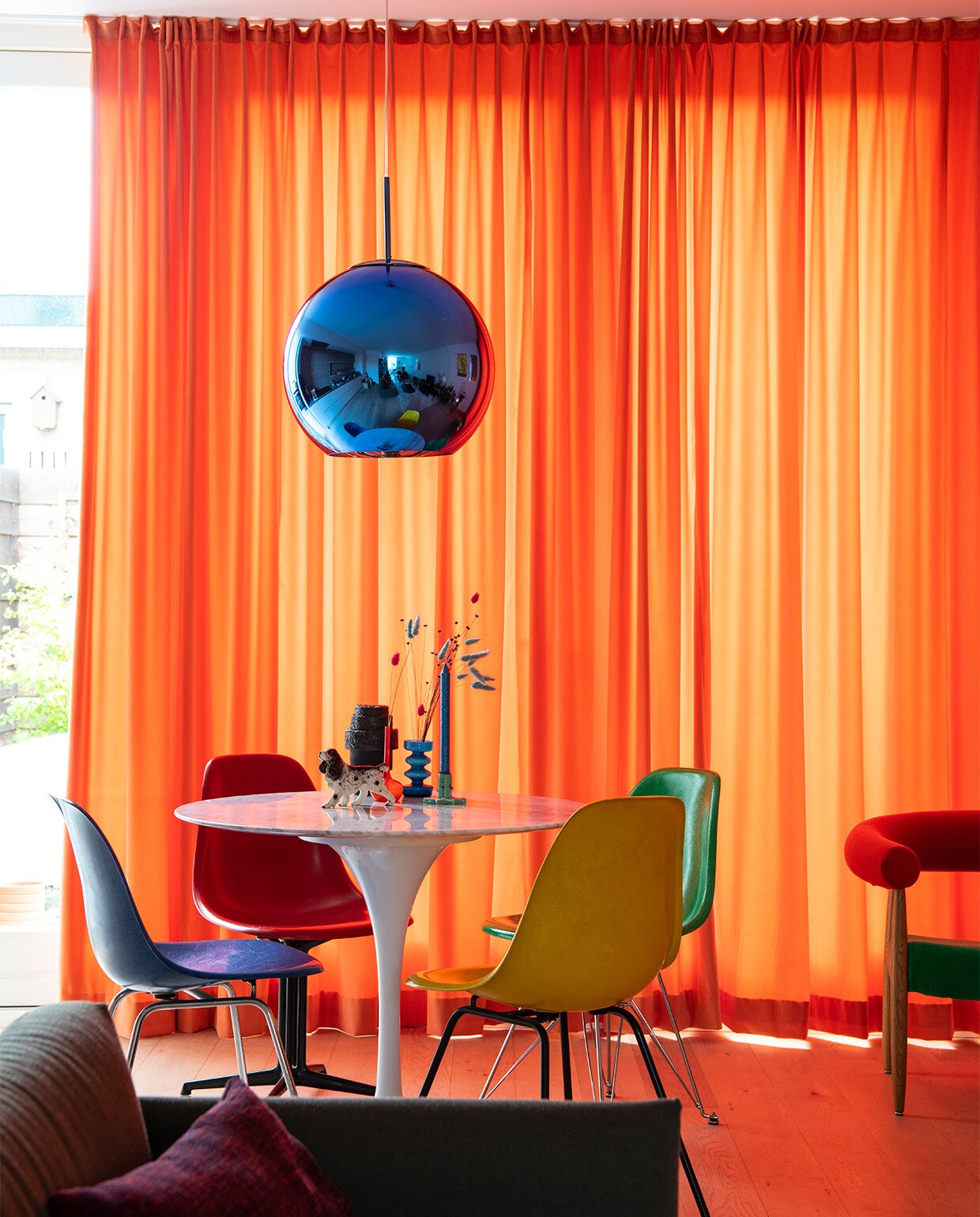 Tulip tafel Eero Saarinen. Stoelen vintage Charles &amp; Ray Eames van Herman Miller/Vitra. Hanglamp Tom Dixon. Zwarte vaas Rudolph Schelling Webermann (RSW). Blauwe vaas van vintagewinkel in Eindhoven. Oranje vaas uit een tweedehandswinkel in Berlijn. Groene kandelaar en beeldje vintage. Fruitschaal Ann Demeulemeester, Serax. Wandtegels tegelsinhuis.nl. Rest onbekend.