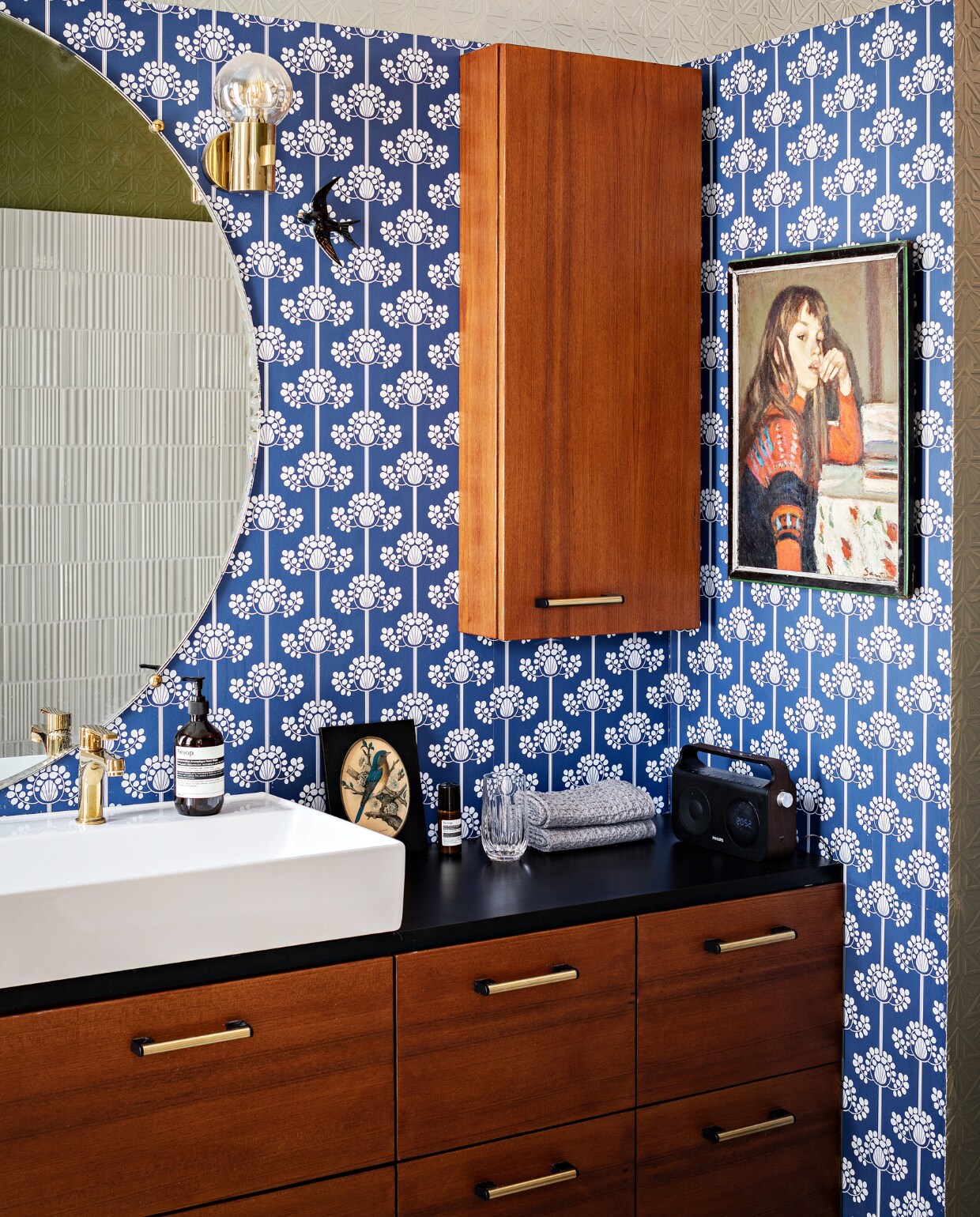 Behang Etoffe. Badkamerkasten Ikea met teakhouten fronten erop bevestigd. Antieke spiegel Carouche. Wandlampen en seventies-prullenbak vintage. Wastafel Bains &amp; Déco. Overig onbekend