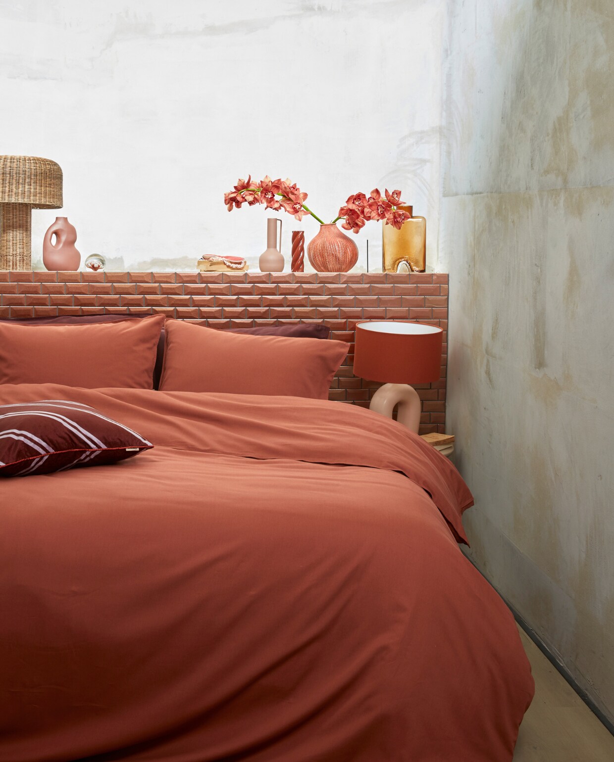 Katoensatijnen dekbedovertrek Earth, 140×200/220 cm € 89,95, 200×200/220 cm € 169,95, 240×200/220 cm € 179,95, fluwelen kussen met bies Diagonal, 50×50 cm € 39,95. M.m.v. nordal.eu (rieten tafellamp Atum), sissy-boy.com (presse-papier, oogmasker, terra gevlochten vaas), loods5.nl/design (gedraaide kandelaar), polspotten.com (roze metalen vaas Roman), mimiettoi.com (glazen vaas). Overig privébezit.