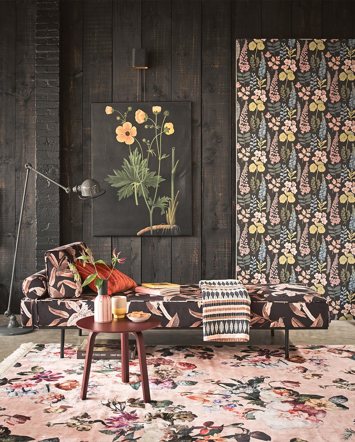 Behang Vivid met bloemenprint € 54,95 (Eijffinger). Velours daybed € 1195,-, veelkleurige plaid € 99,- (HK Living). Vloerkleed met bloemenprint, 180×120 cm € 99,95 (Essenza Home). Steenrood tafeltje € 199,- (Hay). Schilderij bloem € 250,- (Pols Potten). Staande lamp Jieldé € 420,- (Fens Decor). Oranje kussen Amelie Poppy William Yeoward € 159,- (Wilhelmine van Aerssen). Vaas met roze streep € 57,95 (Loods 5). Beker met gele voet, per 2 € 24,95 (Return to Sender).