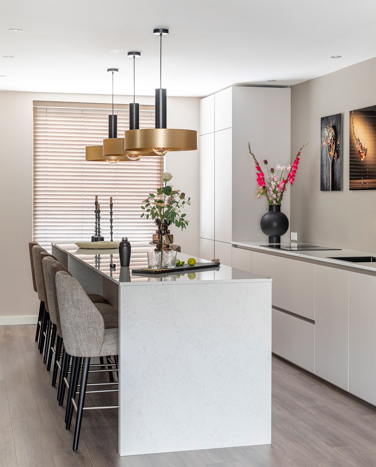 Achter keuken Flexa Strak op de Muur muurverf Boomschorsbruin, muur raamkant en tegenover keuken Flexa Creations muurverf Sandy Steps (flexa.nl). Zwarte stalen taatsdeuren, prijs op aanvraag (gewoongers.nl). Pvc-vloer Moduleo Classic Oak 24864, prijs op aanvraag (woninginrichting-aanhuis.nl). Bamboe jaloezieën kleur 1523, prijs op aanvraag (woninginrichting-aanhuis.nl). Barstoelen Boris in stof Brillance 3882 en stof Cypress 19325 van Eijerkamp Collectie, per stuk € 329,-, hanglampen Gina van Eijerkamp Collectie, per stuk € 149,-, serveerplank van Trendhopper € 24,99, zwarte vaas Georgina van Lightmakers € 79,99, glazen vaas € 24,95, zwarte kandelaars van Lightmakers vanaf € 16,95, papier-maché schaal van Lightmakers € 34,99 (eijerkamp). Bloemen prijs op aanvraag (bloemenweelde-amsterdam.nl). Overig privébezit.