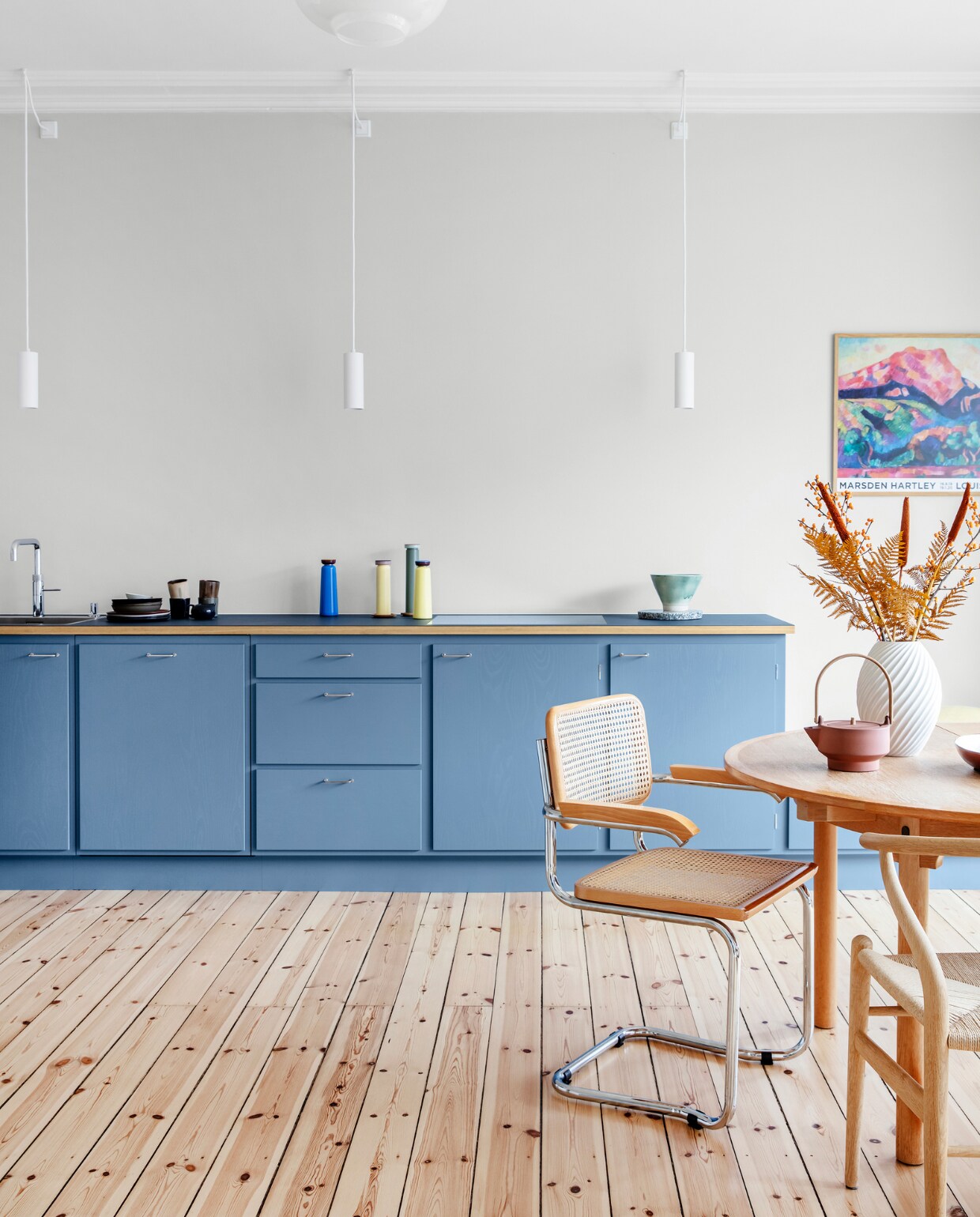 Muurverf Morgendis van Jotun. Keuken Stilleben Architects. Peper- en zoutstel Hay. Tafel Øresund van Børge Mogensen. Vaas Morsø. Theepot Skagerrak og Stilleben. Stoelen Hans Wegner en Marcel Breuer. Originele houten vloer, gerestaureerd. Hanglampen Light-Point. Overig herkomst onbekend.