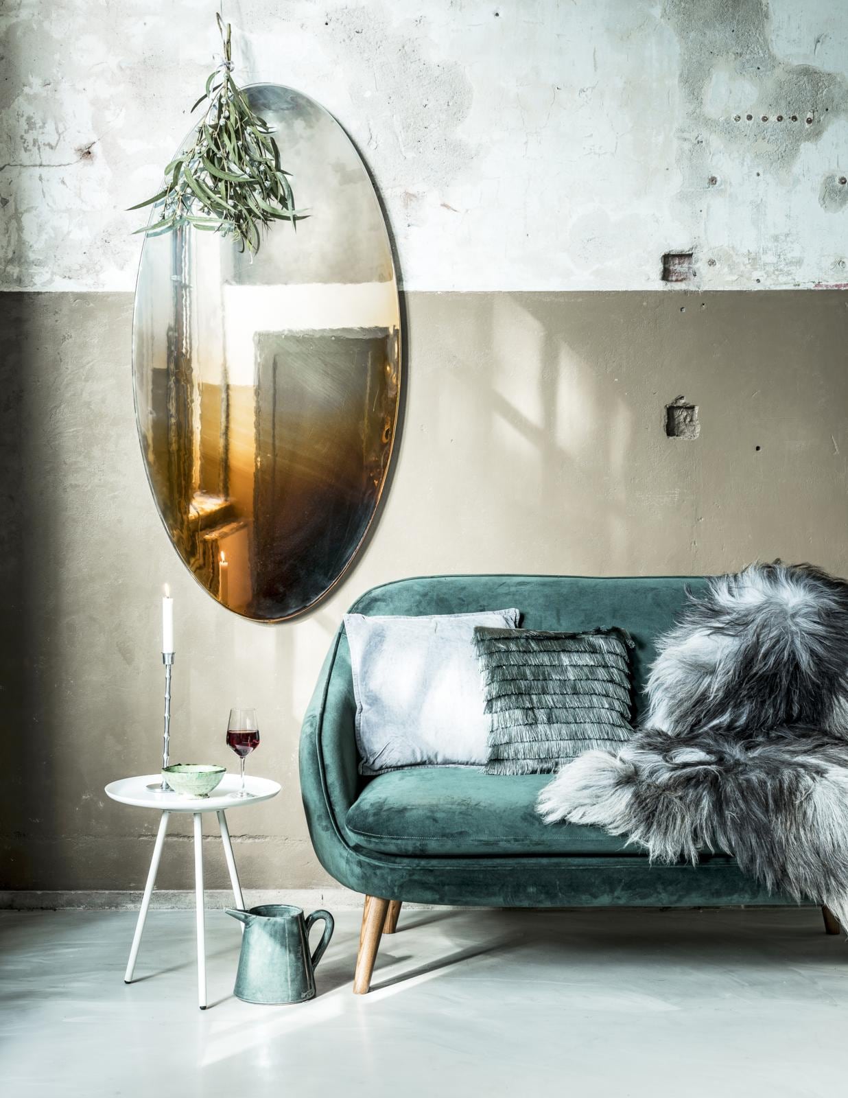 Donkergroene velours bank Flynn € 579,- (sofacompany). Bijzettafel van Zuiver € 69,95, vacht van IJslands schaap € 109,- (Loft). Groen schaaltje Tamgroute van Household Hardware € 10,50 (vtwonen.be). Hoge metalen kandelaar € 14,99, groen kussen met franje € 9,99 (H&amp;M). Wijnglas Hederlig € 1,29 (Ikea). Grijze karaf Tuit € 39,50 (In-Petto). Grijs velours kussen € 29,95 (MrsBloom). Spiegel Picturesque Mirrors van ontwerpster Tjimkje de Boer, 70×140 cm € 1925,- (tjimkje.com).