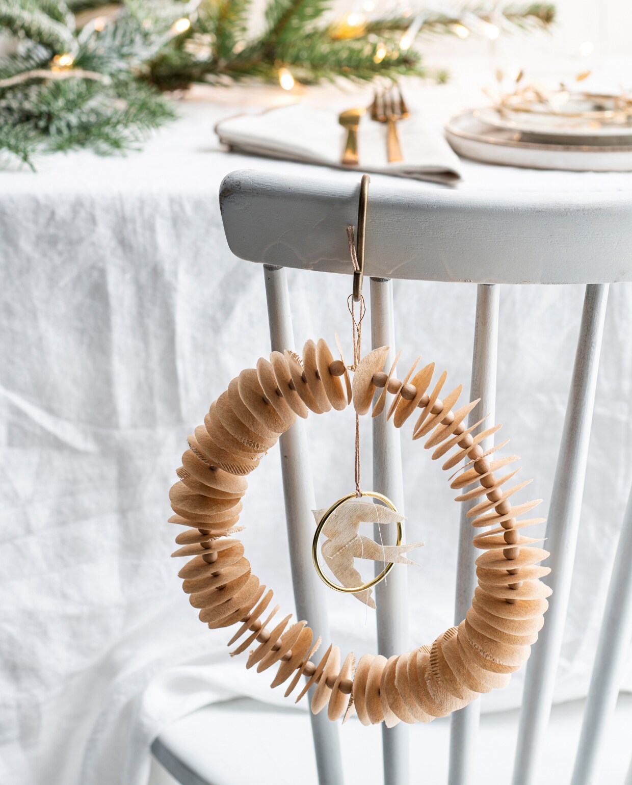 Houten eetkamerstoel, soortgelijke Lotta € 99,-(gewoonstijl.nl). Gewassen wit linnen tafelkleed € 49,99, glas met reliëf en goudkleurige rand, soortgelijk vanaf € 5,99, porseleinen bord met bruine spikkels € 5,99, wit keramieken bord € 9,99, 3-delige bestekset € 9,99, katoenen servet, set van 2 € 7,99. Goudkleurige metalen S-haak van Nordal € 3,15. Overig privébezit.
