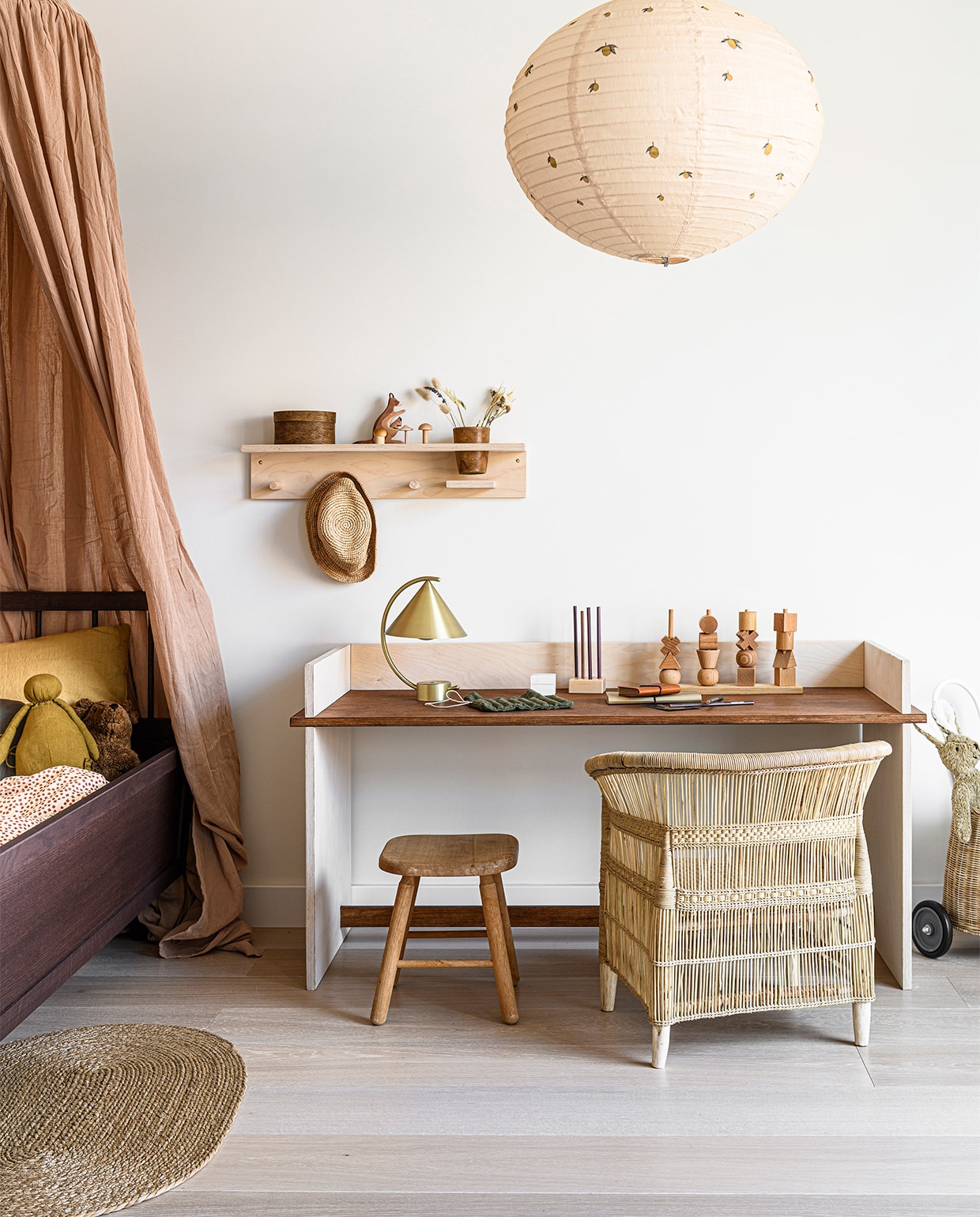 Kinderbureau is zelfgemaakt en komt uit vtwonen DIY special 03-2021. Hemel Bark van Konges Slojd, 300 cm € 99,-, dekbedovertrek buttercup Rosa van Konges Slojd, 100×140 cm € 65,-, stoffen lampenkap met citroenprint van Konges Slojd, 55×45 cm (Øxh) € 121,- (lidor.nl). Junior bed Elin in walnoot, 160x70x50 cm (lxbxh) € 790,- (lotie.nl). Knuffelbeer Floppy van Senger € 50,-, knuffelpop Pigmee doll, Moutarde by A. Société x Pigmee € 45,-, kussen van Studio Feder in kleur Oak, 50×50 cm € 40,- (incl vulling), gevlochten kinderstoel Malawi van People of the Sun € 119,-, houten wandplank Yori shelf van Woodchuck afmeting 60x12x11,5 cm (lxbxh) € 88,-, houten stacking toy van Wooden Story € 35,-, gevlochten mand op wielen van Olli Ella € 59,- (archive-store.nl). Houten kangoeroe met jong van Ostheimer € 24,95 (mijnhemeltje.nl). Houten paddenstoelen uit een set van 15 in een rieten mand van Moon Picnic € 58,50 (regenboogschaap.nl). Messing tafellamp Meridian van Ferm Living € 175,- (vtwonen.be). Groene linnen hoes met krijtjes € 19,50, houten potloodhouder € 7,- (iine.nl). Boekjes met leer-look vanaf € 8,90 (suhka.nl). Overig privébezit.