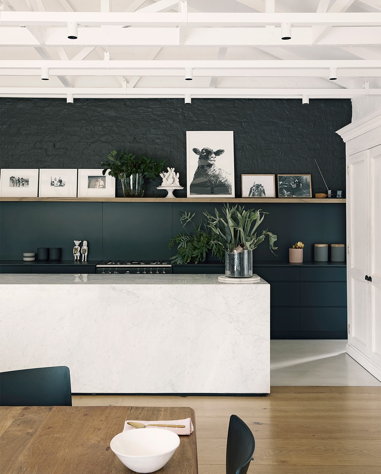 Kleur op de wand: soortgelijk Off Black van vtwonen via Karwei. Eetkamertafel op maat gemaakt met vintage poten en nieuw blad. Stoelen Spazio. Marmeren keukeneiland op maat gemaakt, soortgelijk By Sensa en Grillo. Kast kringloopwinkel, soortgelijk Old Basics. Overig onbekend.