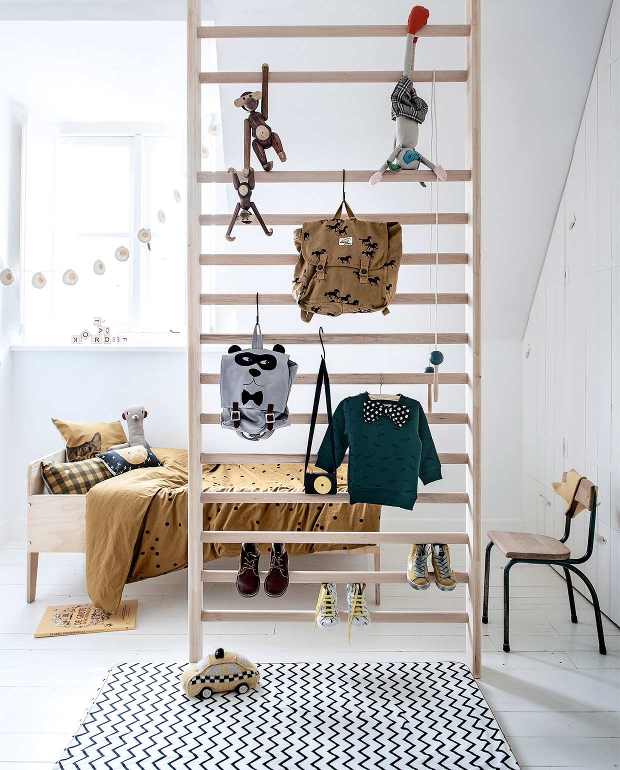 Slinger € 79,-, grijze rugtas van Emile et Ida € 65,-, groene trui van Simple Kids € 84,- okergeel gebreid kroontje € 27,50, springtouw van Nobodinoz € 15,95, gele gympen van Golden Goose € 160,-, schoenen met zebraprint van Maá Shoes € 125,-, hoge bruine schoenen van Rainbow &amp; Snow € 110,-, gebreide NYC taxi van Oeuf NYC € 75,- (Orange Mayonnaise). Houten alfabetblokken van Ooh Noo € 59,90 (Rewind Design). Houten apen van Kay Bojesen, klein € 119,-, medium € 339,- (www.vtwonen.be). Muisknuffel € 39,95, schooltas Horses van Bobo Choses € 68,95, juniorbed Crisis van Piet Hein Eek € 265,-, stokstaartknuffel € 37,95, geruit kussen Vichy van La Cérise sur le Gâteau € 37,95, grote avonturenatlas € 24,95 (Imps &amp; Elfs + Friends). Klein zwart kussentje met katopdruk van Mimi’Lou € 29,95, matras met zigzagdessin van Nobodinoz € 52,95 (www.psikhouvanjou.nl). Oud schoolstoeltje € 25,- (Loods 5). Dekbedovertrek Odette van La Cérise sur le Gâteau € 95,-, okergele kussenhoes met kattenhoofd Zwicky van La Cérise sur le Gâteau € 40,- (Living). Camera van houtresten is zelfgemaakt. Overig privébezit.
