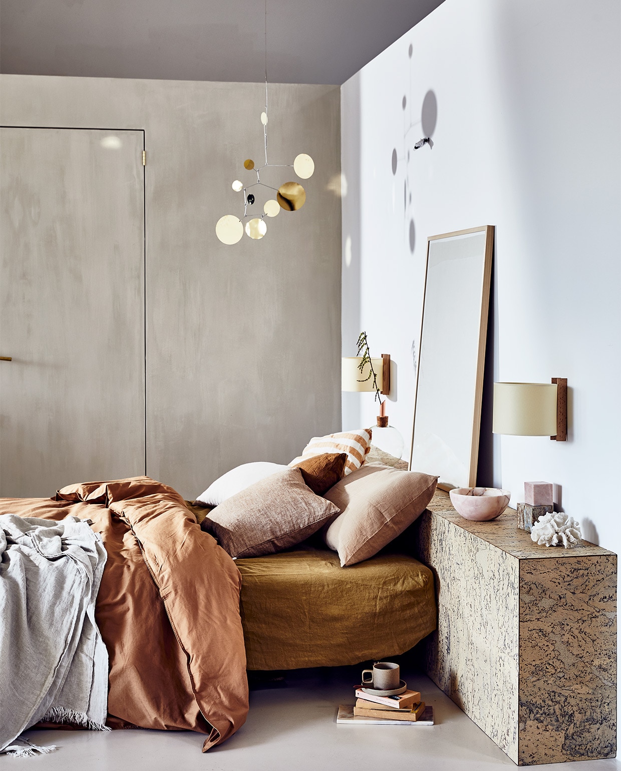 Headboard gemaakt van duurzame kurken wandtegels, 30×60 cm per m² € 24,50 (24kurk.nl). Messing mobile Lappalainen € 250,-, wandlampen van Santa &amp; Cole € 220,-, beker van Hasami Porcelain € 26,-, beddengoed van biologisch katoen van Midnatt, 220×240 cm € 120,-, matrashoes van Linge Particulier € 160,-, gestreept kussen van Linge Particulier, 40×40 cm € 44,95 (pantoufle-design.nl). Linnen plaid € 139,-, linnen kussens Nutmeg 50×50 cm € 45,-, bruin kussen 50×50 cm € 45,-, roze kussen 50×50 cm € 45,- (bymölle.com). Schilderij Fant, prijs op aanvraag (sukha.nl). Roze marmeren schaal vanaf € 49,95, marmeren kubussen vanaf € 29,95 (stonedmarble.com Fresco kalkverf op de muur in kleur Coffee Cream, per liter € 44,90 (pure-original.nl). Koraal privébezit.