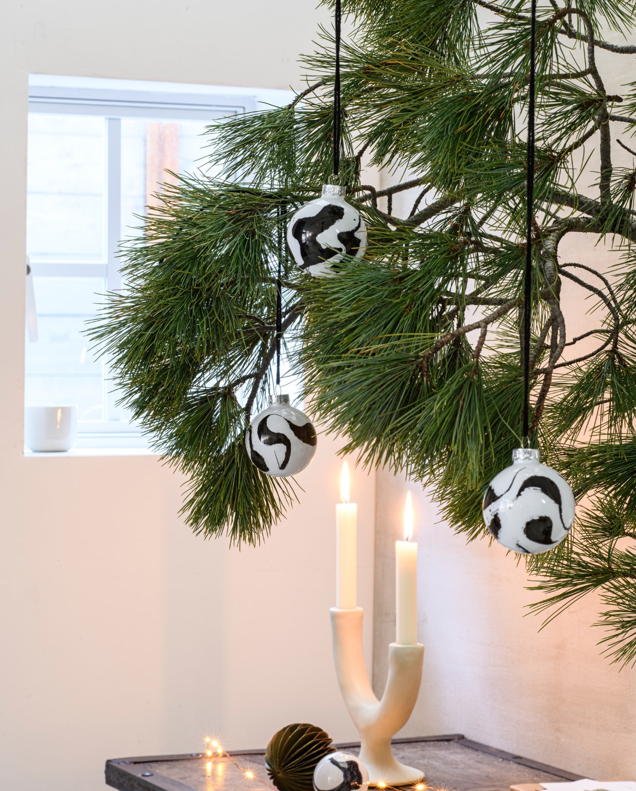 Kandelaar two arms ecomix van Urban Nature Culture € 39,99 (fonq.nl). Papieren honeycomb kerstbal € 2,69 (intratuin.nl). Dinerkaars € 0,95 (dille-kamille.nl).
