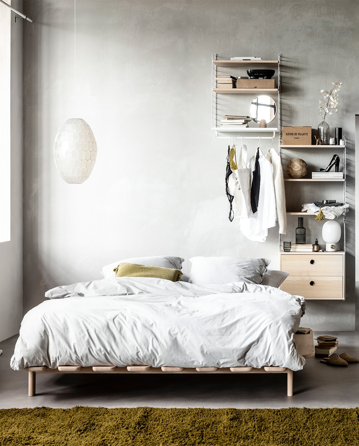 Muurverf kleur North, per liter € 30,- (bauwerkcolour.com). Wandsysteem met witte draadstalen panelen en planken, deuren en werkblad in kleur Ash, vanaf € 1983,- (stringfurniture.com). Vloer Novilon kleur Beton van vtwonen, 200 cm of 400 cm breed, exclusief installeren per m² € 28,95 (vtwonen.be/vtwonen-collectie). Gordijn Dazer van Kinnasand, 320 cm hoog per meter € 125,-, witte houten vlinderstoel € 421,- ronde houten opberger met deksel € 165,- (coosdewitwonen.nl). Parelmoeren hanglamp € 129,-, ronde spiegel op eikenhouten poot € 139,-, canvas tas € 19,90, bruin flesje olie € 12,90, eikenhouten lijst vanaf € 26,90, doosjes met knoopjessluiting per stuk vanaf € 15,50, plastic kratten per stuk vanaf € 15,50, witte kartonnen opbergers per stuk € 9,90, zachtgrijze leren tas met bruin leren koord € 129,90 (letoile.store). Massief beukenhouten bed Modest vanaf € 1390,- (loof.nl). Dekbedovertrek met bijpassende slopen van percal katoen in kleur Misty Grey vanaf € 99,95 (yumeko.nl). Sierkussen € 29,95, raffia instappers € 49,95 (zarahome.com). Okergeel berberkleed, verkrijgbaar in elke maat en kleur, 220×340 cm € 1875,- (paullelieveld.com). Zwarte ovale marmeren schaal op poten van Ferm Living € 77,35, grijze glazen karaf van Ferm Living € 35,-, set van 4 € 39,- tafellamp met grijze betonnen poot van Menu € 179,-, tafellamp met gebroken wit onderstel van Menu € 170,99 (vtwonen.be). Zwart houten object in cilindervorm € 15,95 zwart houten object in puntvorm € 25,95, zwart houten opbergschaaltje € 12,95 (loods5.nl). Metalen brillenkoker € 16,95, grijze fluwelen toilettas met gele kwast € 19,95 (maisonnl.com). Overig privébezit.