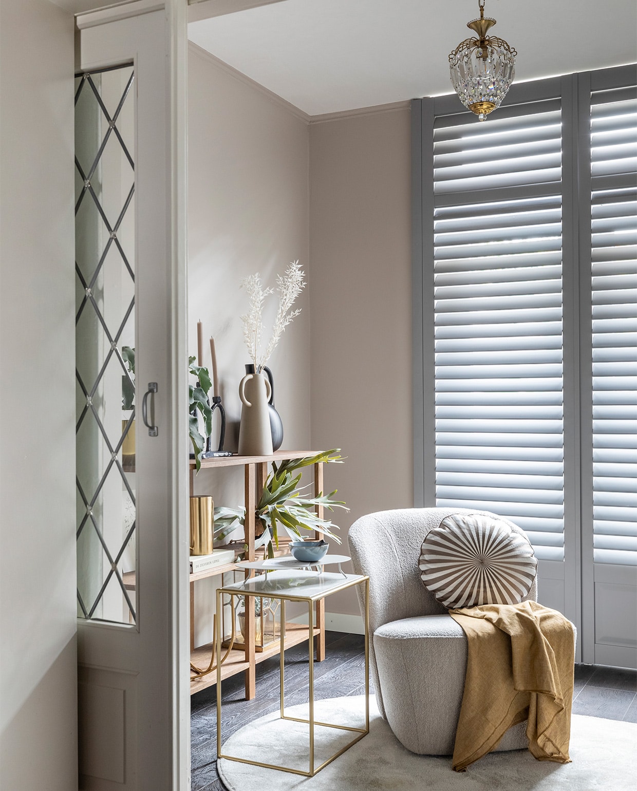 Flexa Easycare Muren muurverf Urban Taupe (flexa.nl). Shutters in de kleur Signal Grey, prijs op aanvraag (jasnoshutters.nl). Pvc-vloer Country Oak 54991 van Moduleo, prijs op aanvraag (woninginrichting-aanhuis.nl). Fauteuil van vtwonen € 279,-, zwarte kan € 65,- (eijerkamp.nl). Sprei € 335, kussen € 95,- (bungalow.dk). Zwarte kandelaar van designer De Ling, prijs op aanvraag (instagram.com/junoonbyjanicejill/). Bijzettafel, set van 2 € 457,58, gieter € 56,- (nordal.eu). Grijs plateau op de bijzettafel € 109,99 (kwilleminhuis.nl). Kunstwerken artprint flora, prijs op aanvraag (maartjevandennoort.nl). Lepel van vtwonen, set van 2 € 12,55, kom van Serax, 12-delige set € 199,- (vtwonen.nl). DIY wandkast van vtwonen (vtwonen.nl/diy). Gouden plantenpot € 14,99, plantenpot in stolp € 4,99 (hm.com). Kunstplant prijs op aanvraag (silk-ka.com). Plant, droogtakken, prijs op aanvraag (plantje.nl). Overig privébezit.