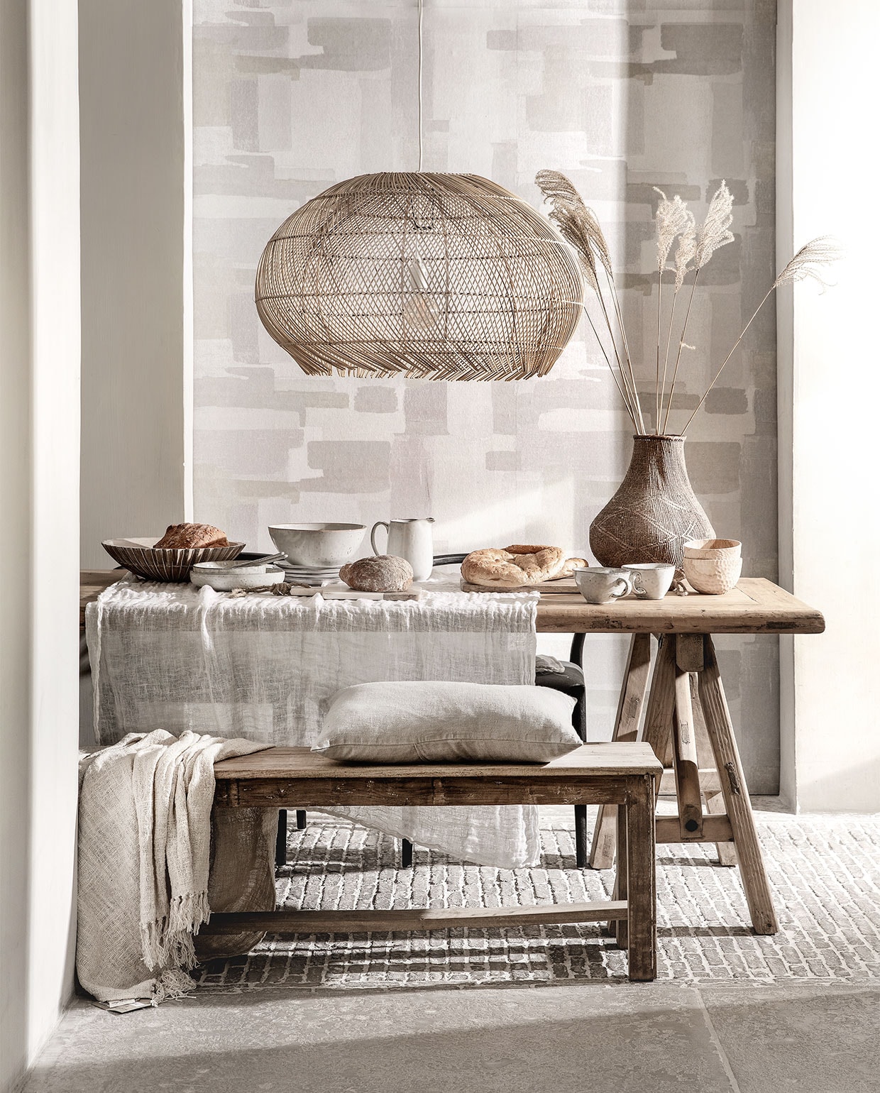 Behang Lino, 106 cm breed per meter € 15,95 (eijffinger.com). Rieten hanglamp € 229,95 (manggisliving.nl). Houten whitewash schaal Marseille € 92,50 (mrsbloom.nl). Servies Broste Copenhagen; schalen v.a. € 19,95, grote schaal € 39,95, kan € 33,95, bord € 11,95, grote kom met oor € 15,95, bewerkte houten schaaltjes per stuk € 39,95 (loftloft.nl). Linnen kussen € 49,95, eettafel van oud hout, 260×90 cm € 1795,-, oud teakhouten bank 176 cm breed € 245,- (hetkabinet.nl). Grof geweven plaid € 87,95 (heinshome.nl). Vaas € 69,- (stylexclusief.nl).