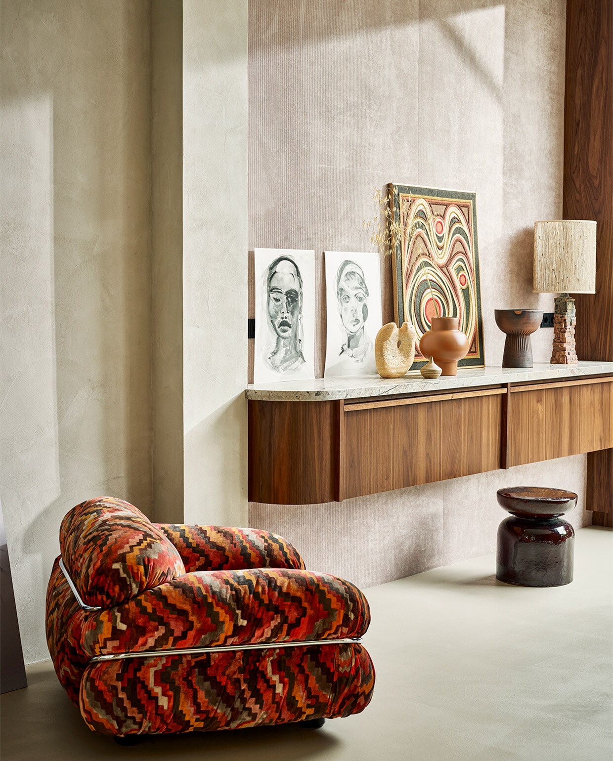 Fauteuil van Gianfranco Frattini voor Cassina € 3000,- (sitonvintage.com). Portretten door @anita_jollespaintings, prijzen op aanvraag (byjanekate.com). Vintage schilderij van geborduurde stof, 69×89 cm € 400,-, keramieken lamp met kap van Bernard Rooke, € 700,- (vintagehoarder.com). Oranjerode vaas € 69,- (couleurlocale.eu). Travertin beeld Natuurlijke Balans van Mirjam de Nijs, 27x20x8 cm, prijs op aanvraag (beeldenvansteen.nl). Rechterdeel van de muur bekleed met ribfluwelen wandbekleding Tinneroy Lush, 135 cm breed, per meter € 199,- (arte-international.com). Overig privébezit.