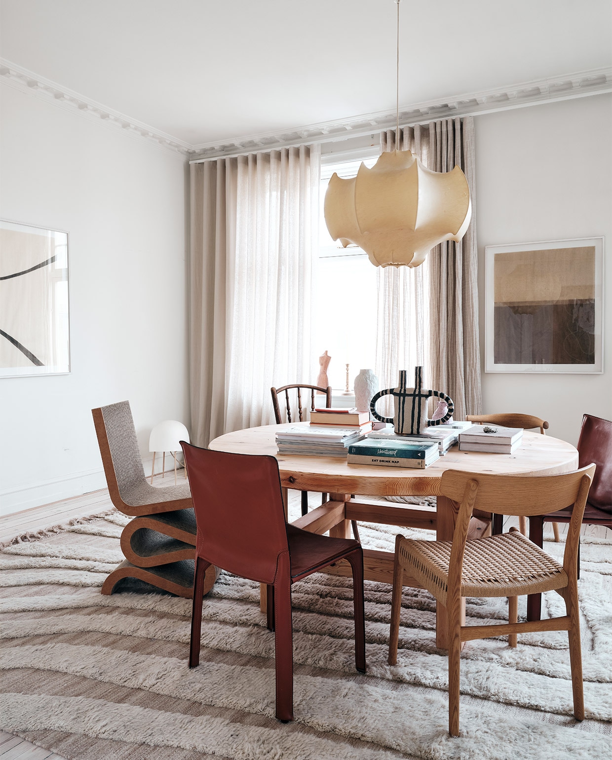 Kleed Cappelen Dimyr, vintage tafel Bukowskis, erop keramiek van Emelie Thornadtsson, Side Chair Vitra, stoelen van onder meer Cassina, Paustian en vintage exemplaren. Vintage Flos hanglamp, gordijnen Astrid Textiles, kunstwerk van, antieke sidetable, vazen Ilis Art en Svenskt Tenn, kunstwerk Kristoffer Lindfors.