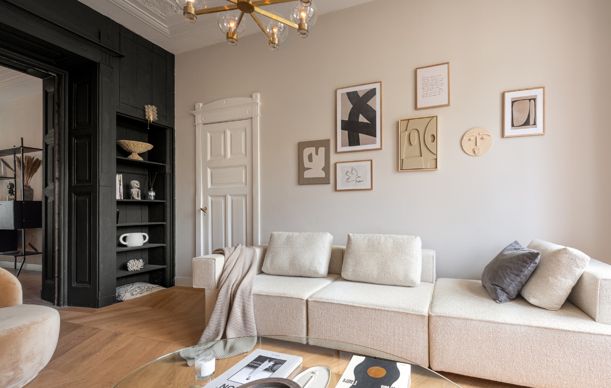 Bank Flow Rotterdam, posters van Desenio, kunstwerk door Edith Beurskens voor The Poster Club, muursculptuur Huis vol Stijl, salontafel en plafondlamp vintage van Hans Agne Jakobsson, wandlampen vintage van Helena Tynell, plaid Made, accessoires in kast van Maison Jolie, vintage en souvenirs. Overig onbekend.