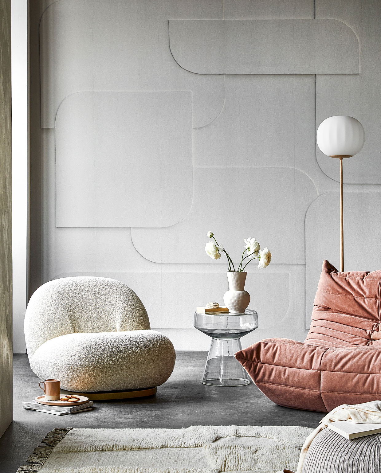 Digitaal behang Soft 3D light grey, 6 banen van 280×50 cm, totaal (lxb) 280×300 cm € 149,-. M.m.v. kasstoor.nl (witte fauteuil, roze fauteuil, vloerlamp), homestede.nl (houten dienblad, poef), paviljoennoord.com (mok, shirt), loods5.nl/design (glazen bijzettafel), zara.com (vaas, schoenen), hm.com (vloerkleed), pure-original.nl (muurverf Freso in kleur Sea Salt). Overig privébezit.