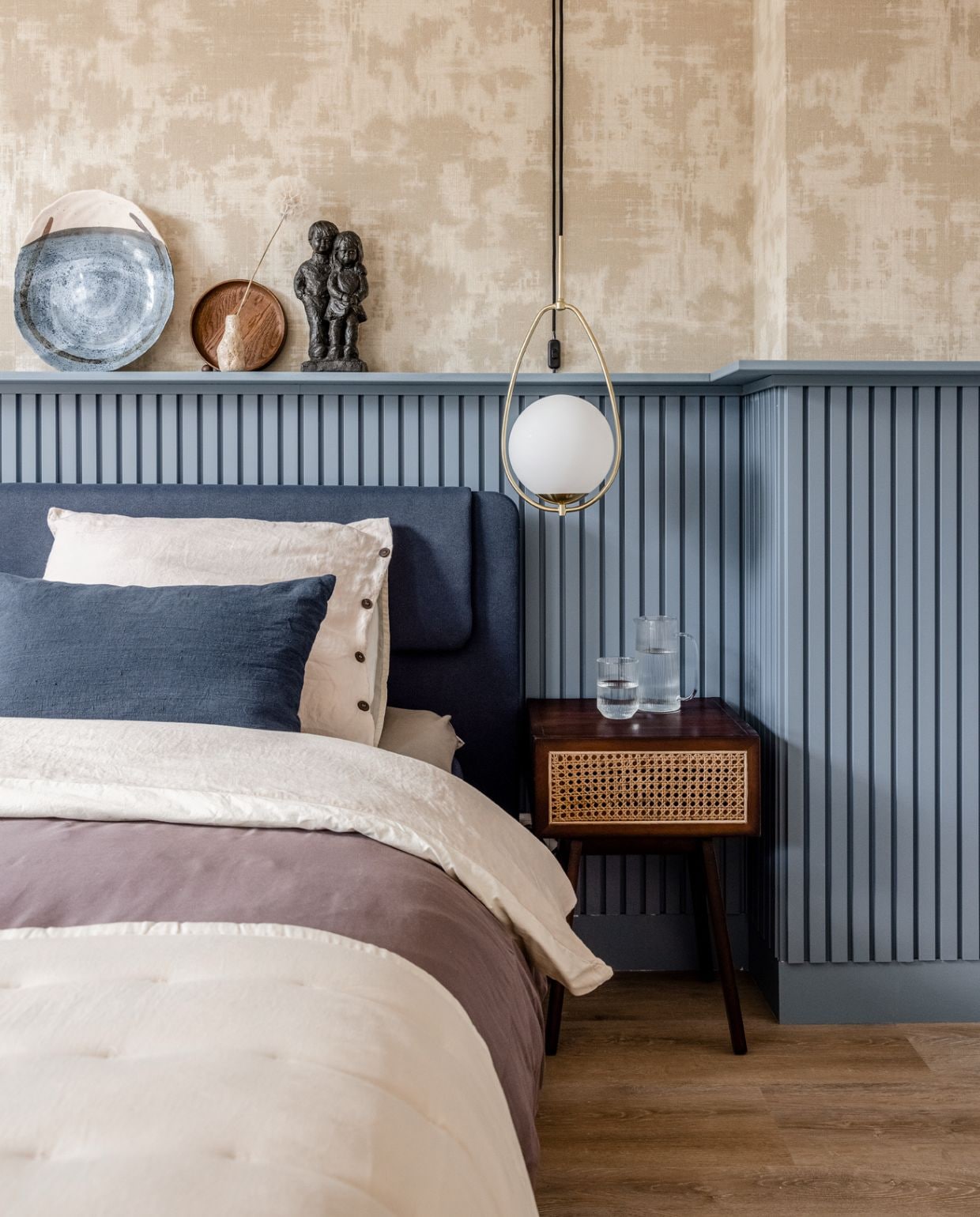 Verf lambrisering Denim Drift (Flexa). Lambrisering gemaakt van wandpanelen Orac Decor, spuitwerk Voordelig Latex Spuiten, Behang Canvas 313520 (Eijffinger). Plafondspots Lightinova. Hanglampen amelie van Vestbjerg vtwonen. DIY kabels gemaakt van een trekontlaster, zwarte stekker, stalen vogelrol, snoer schakelaar Hornbach. Bed, Taupe dekbedovertrek Coco, Naturel dekbedovertrek Nikko, Taupe hoeslaken Jersey, Sprei Ruth, (beterbed.nl. Blauwe linnen kussens indigo (By Mölle). Nachtkastje, Beige poef (H&amp;M). Wandbureau, Beige vloerkleed, Marmeren spiegel (Nordal). Tafellamp Torso van Menu (Eijerkamp). Waterkan, Waterglas (Zara Home) Op de lambrisering: Roestvrijstalen beeld (H&amp;M). Donkerbruin dienblad (vtwonen). Kleine vaas van Ferm Living (Eijerkamp)., Overig privébezit