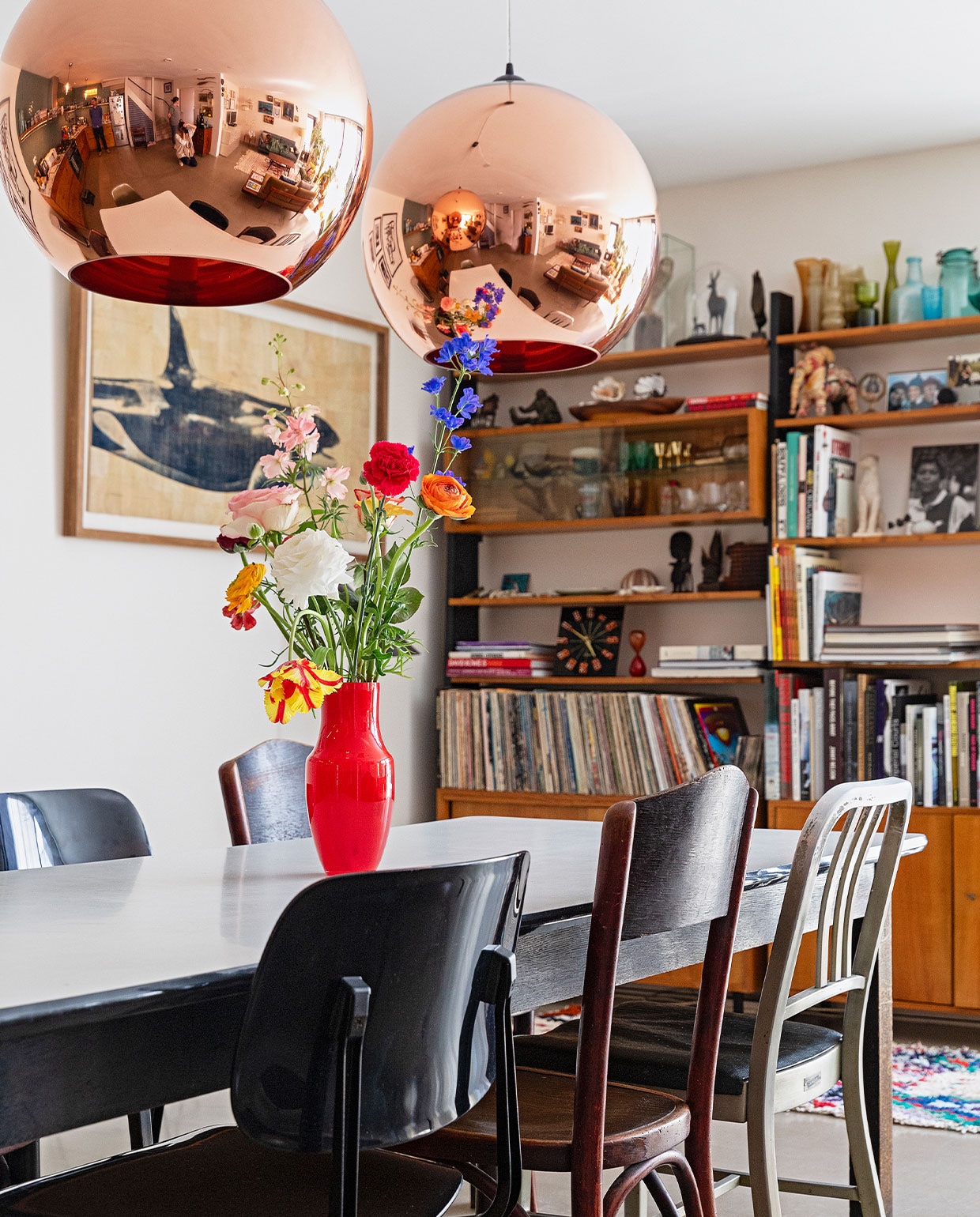 Eettafel Neef Louis Design, eetstoelen Revolt Ahrend, houten stoel erfstuk, oude politiebureaustoel rommelmarkt New York, rode vaas Hema, kunstwerk Salvor, vloer zandcement met twee componenten hoogglanslak, kleed The Souks, boekenkast DasGaaf, vazen op de kast vintage vondsten, koekoeksklok overgebleven na een fotoshoot, overige spullen in de kast herkomst onbekend.