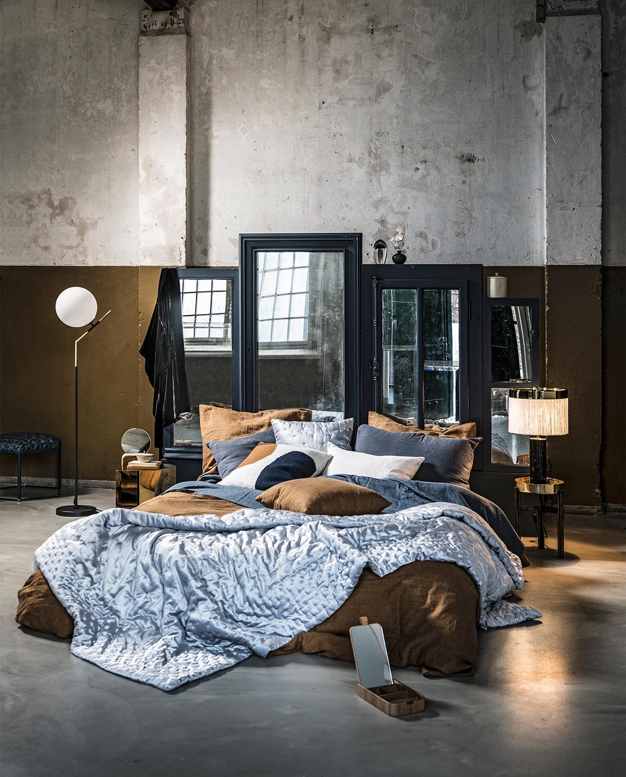 Hoofdbord met oude spiegels erin verwerkt, prijs op aanvraag (com-anders.nl). Vloerlamp met witte bol, Sisi van Lifestyle, 50×151 cm (bxh) € 249,-, spiegel met houten bakje van HK Living € 47,95 (vtwonen.be). Gouden nachtkastje € 159,- (hay.dk). Zwarte badjas € 99,99, zilverkleurige plaid 230×250 cm € 199,-, zilverkleurig kussen € 35,99 (zarahome.com). Bruin dekbedovertrek vanaf € 139,-, kussenslopen vanaf € 28,-, linnen kussens vanaf € 45,-, blauw laken € 119,- (bymolle.com). Kussen met blauw rondje € 69,- (homestede.nl). Ronde houten tafeltje met gouden blad Twelve van Gallotti&amp;Radice € 1430,-, lamp met witte stoffen kap Orsola van Tato € 1752,-, blauwe poef naast staande lamp € 1554,-(edha-interieur.nl). Ornament kwal € 39,95, blauw vaasje € 19,95,-, wit potje met deksel klein € 17,50, groot € 22,50 (maisonnl.com). Bakje met spiegel op voorgrond € 19,95 (wonenmetlef.nl).