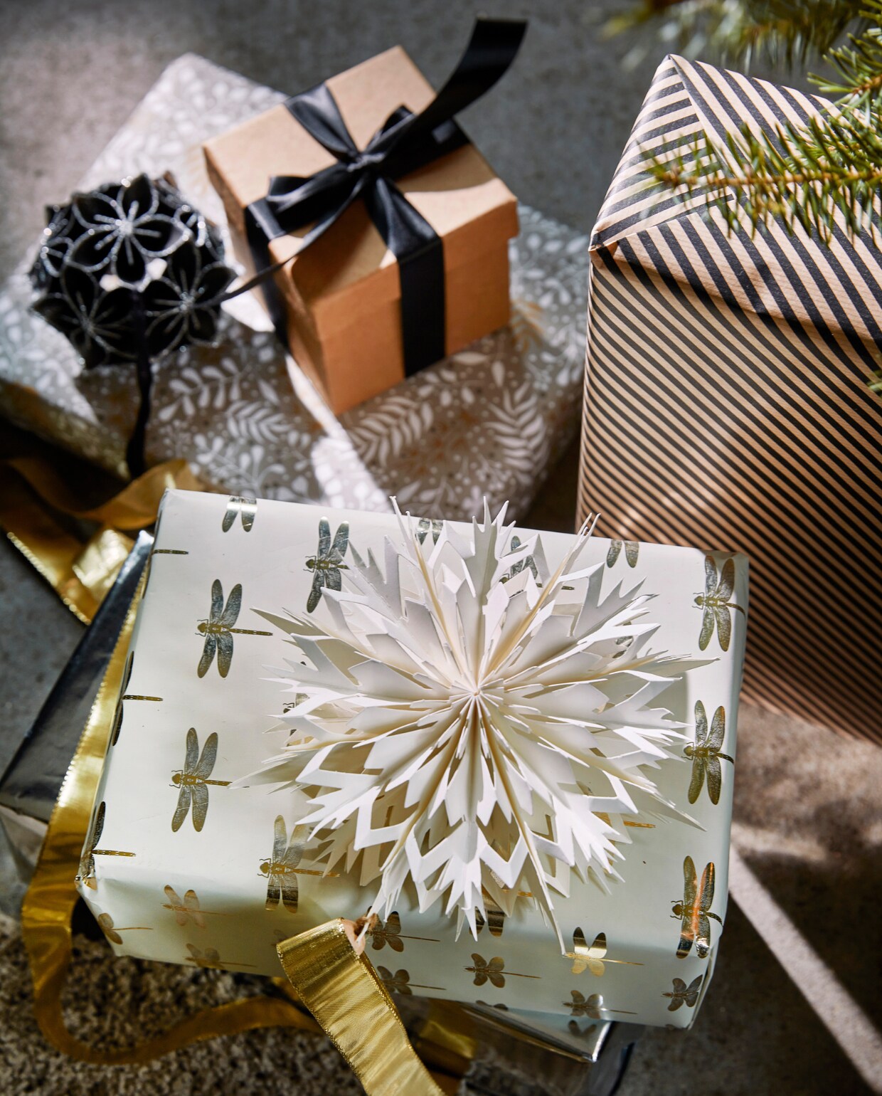 Zwart papieren ornament bloem met glitter, 10 cm (Ø) € 5,99, wit papieren ornament, 30×7 cm (Øxd) € 3,99.