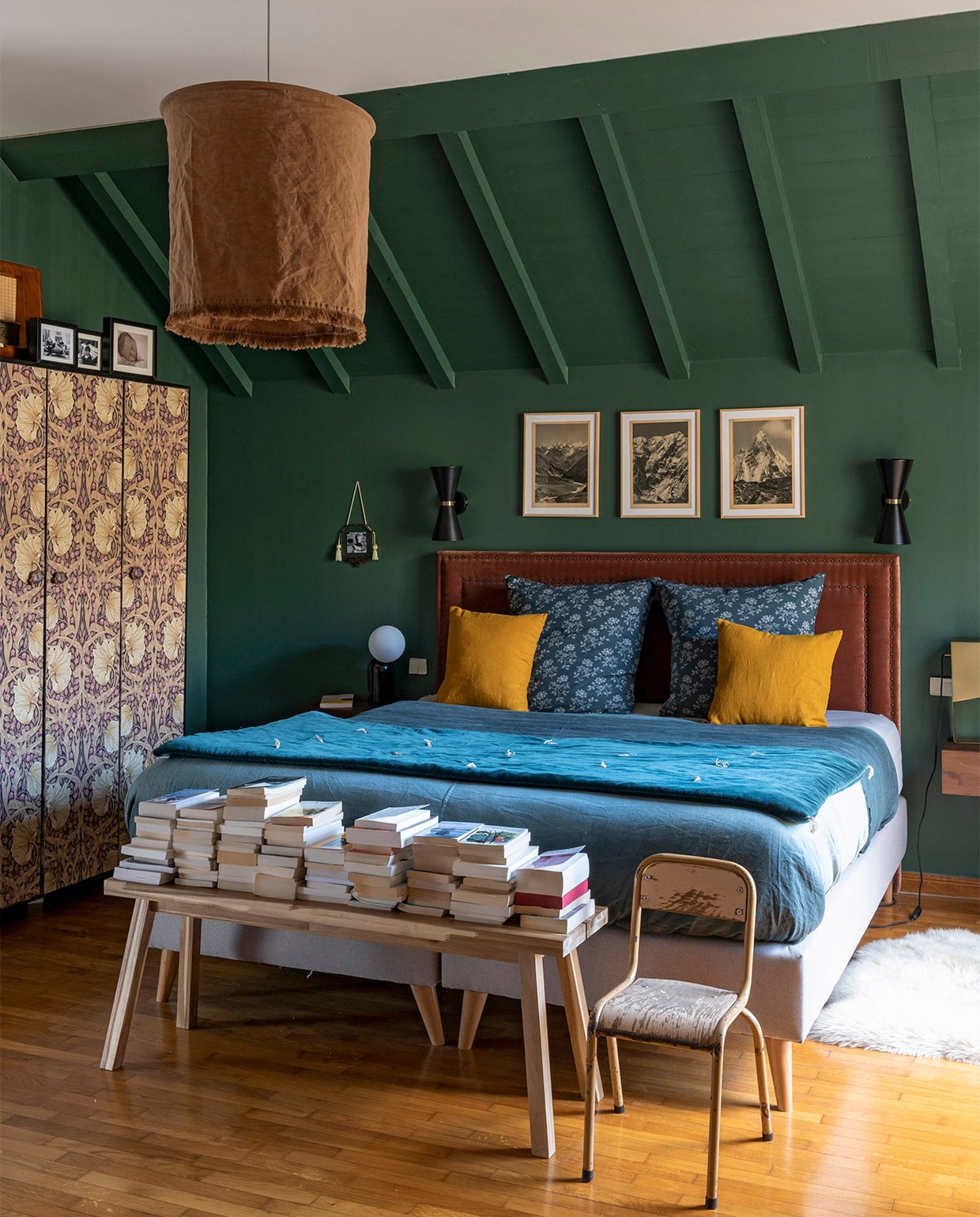 Muurverf groen zelf gemengd, prints bergen vintage, kledingkast vintage met William Morris behang, wandlampen Made, hoofdbord en nachtkastjes AMPM La Redoute, hanglamp Madam Stoltz, beddengoed Lab Boutique, kussens Camomile London, sprei Caravane, vloerkleed Fab Design, bankje Ikea, overig vintage.