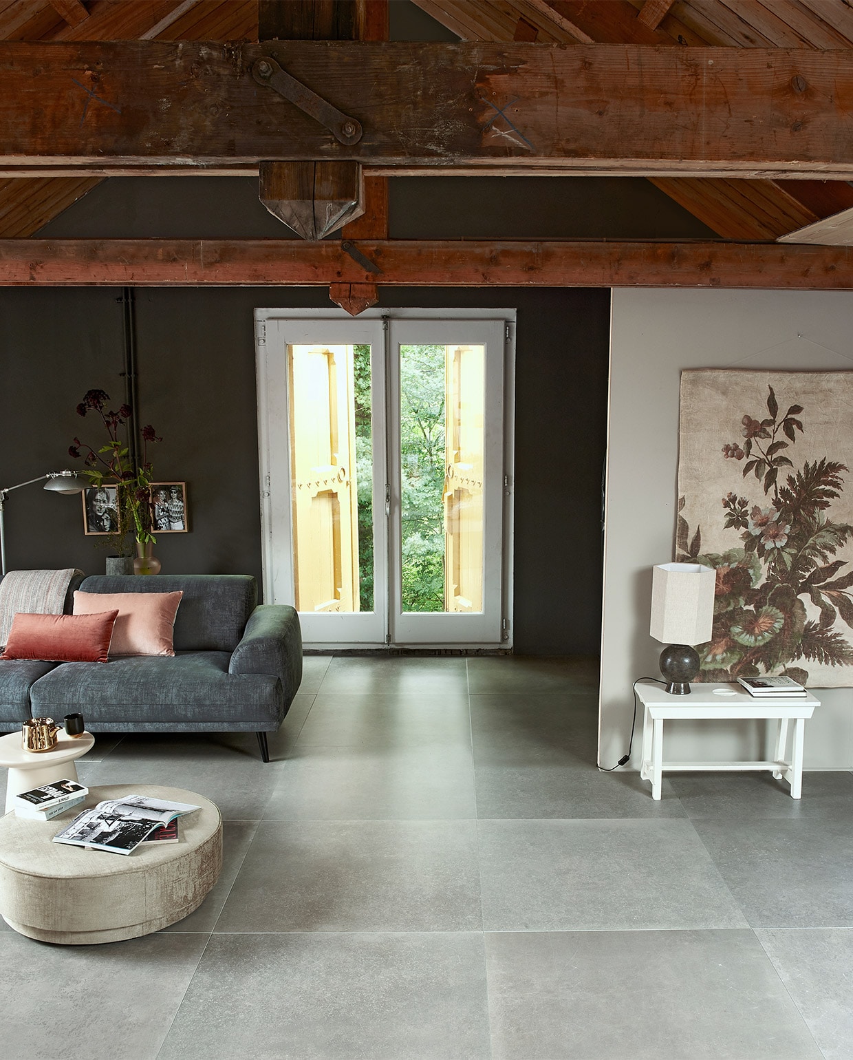 Vloertegel concrete taupe uit vtwonen collectie (helaas niet meer verkrijgbaar) M.m.v. vtwonen.nl (bank, poef) hkliving.nl (tafeltje, lamp, wanddecoratie, vaas, theepot), loods5.nl (kommetje, houten lijsten). Verf op muur vtwonen Warm Grey