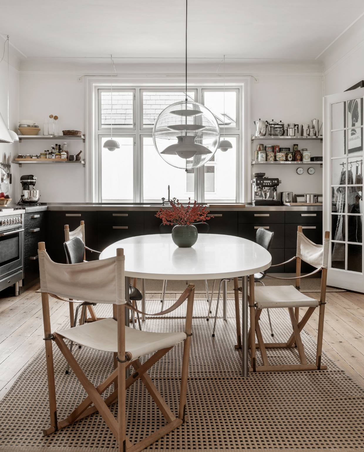 Ronde tafel Marianne Wegner, twee Series 7 stoelen van Arne Jacobsen, drie vouwstoelen van Mogens Koch, hanglamp Globe van Verner Panton, ruim twintig jaar oud papiergaren vloerkleed van Woodnotes. Overig onbekend.
