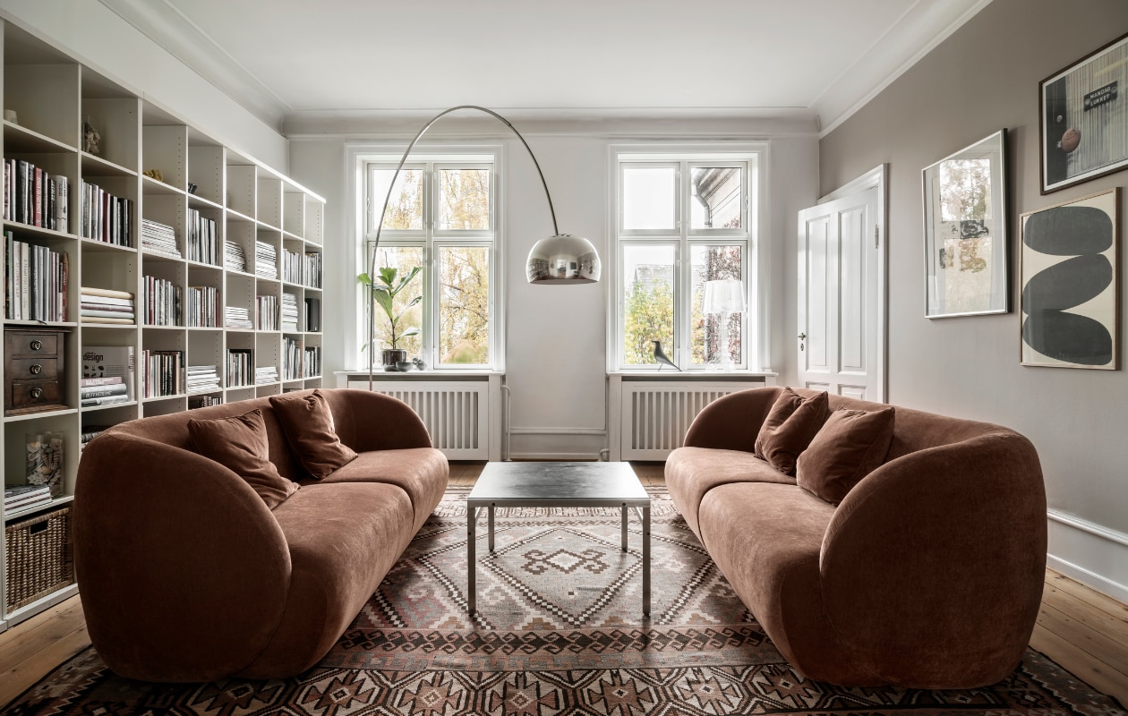 Bank Paula van Sofacompany, vintage kelim vloerkleed jaren geleden gekocht, salontafel gemaakt door Line’s vader, vloerlamp Flos Arco, boekenkast Ikea, vierentwintig jaar oud. Kunst aan de muur met de klok mee: zwart-witte litho gekocht bij Gallery Op Ad Trappen Kopenhagen, foto van fotograaf Pernille Enoch, grafisch werk Nina Bruun voor Paper Collective.