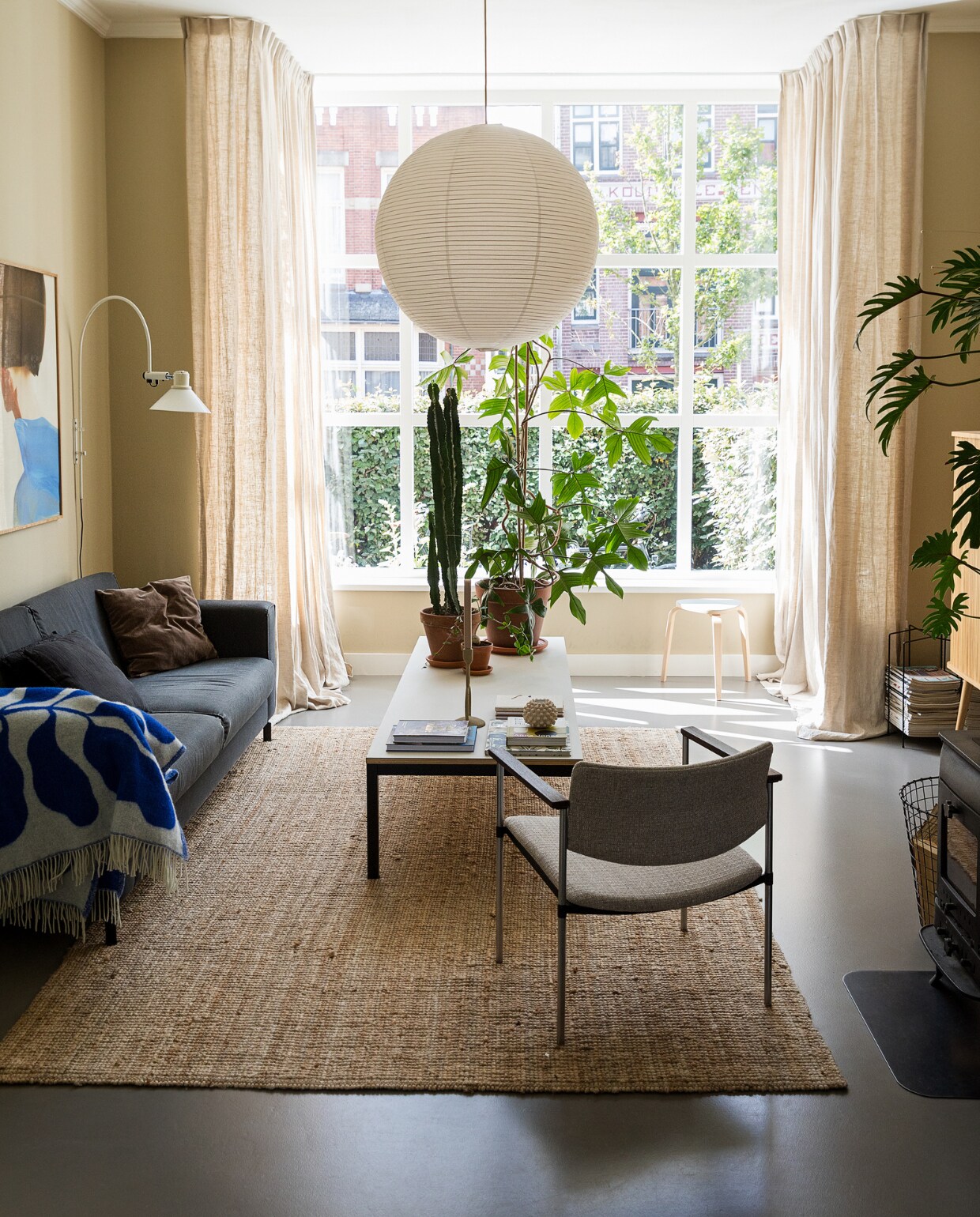Muurkleur GN 080-08. Hanglamp Hay. Bank onbekend. Stoel Kembo via vintagemarket12. Salontafel zelfgemaakt. Plaid van Linnea Andersson voor Arket. Wandlamp vintage. Tijdschriftenrek Designtorget. Vloerkleed Ikea. Kruk Trinity Furniture. Print van Amelie Hegardt, boeken, planten via Nørd Conceptstore. Notitieboeken Monk &amp; Anna. Kandelaar Broste Copenhagen. Waxinelichthouder Jotex.