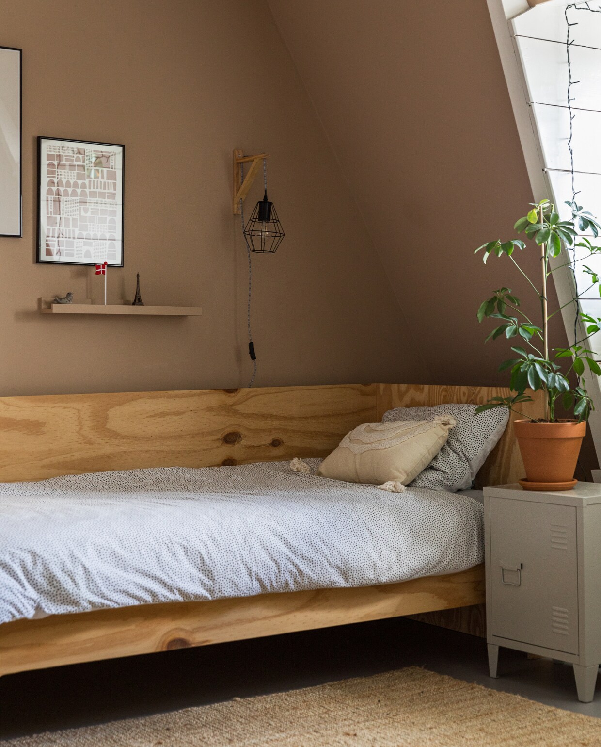 Muurkleur GN-087-07. Bed zelfgemaakt. Beddengoed, sierkussen Hema. Lamp, nachtkastje Kwantum. Vloerkleed, wandplank Ikea. Print van Silvia Visscher. Plant via Nørd Conceptstore.