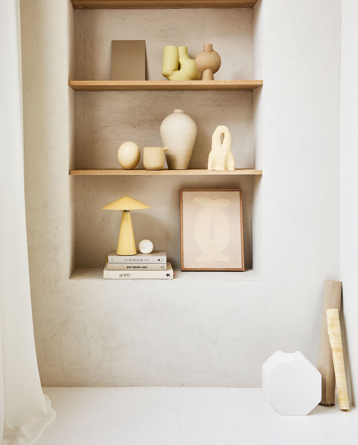 Vaas Shell Pot van Ferm Living € 99,-, vaas Forma large van Bolia € 90,- (vtwonen.nl). Lichtblauwe kandelaar van &amp;Klevering € 35,- (groenenakker.nl). Witte kom op trap € 39,99 (zarahome.com). Vazen met bol erop op bovenste plank prijs op aanvraag (byjoa.nl). Witte vaas cirkel € 14,99 (hm.com). Vaas van 101CPH op tweede plank € 39,- (debijenkorf.nl). Schaal op voet € 59,95 (urbannatureculture.nl). Overig privébezit.