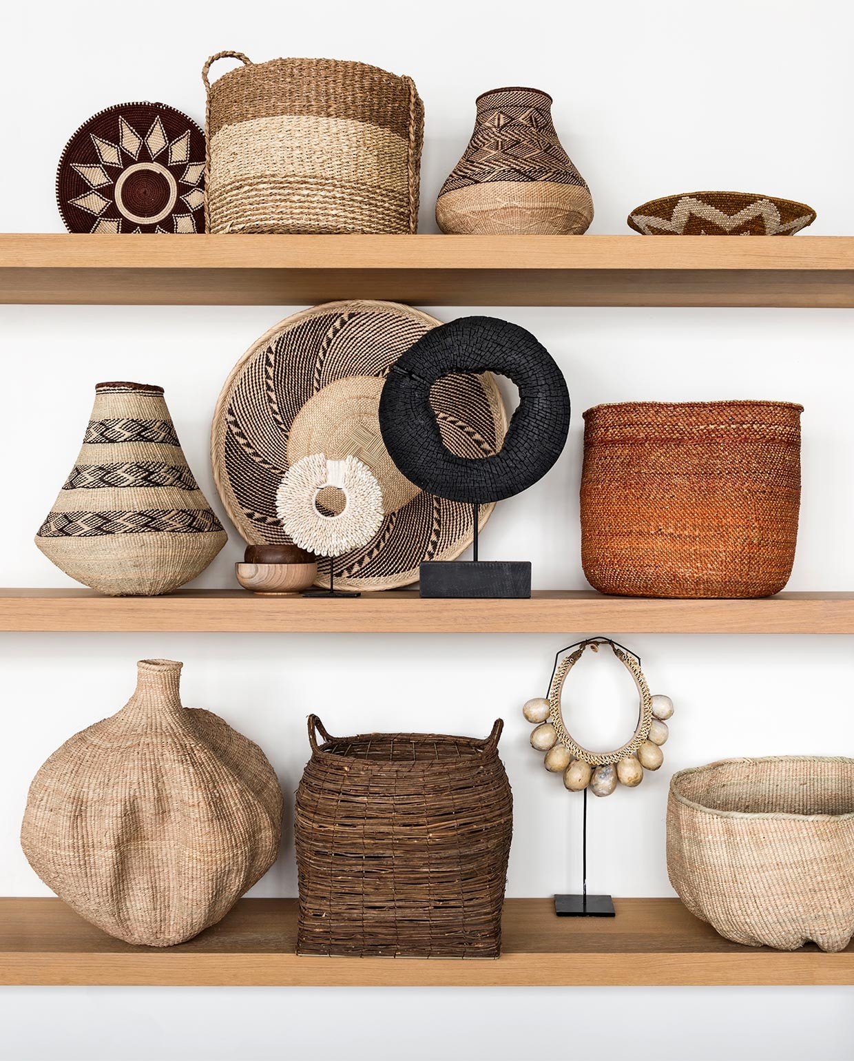 Eikenhouten planken prijs op aanvraag (Amsterdamsche Fijnhouthandel). Onderste plank van links naar rechts: Bulawayo Gourd basket € 72,- (boxworx.nl). Mand met hengsels € 43,95 (Storebror). Mand van palmblad uit Zimbabwe € 109,-(Couleur Locale). Ornament privébezit. Middelste plank van links naar rechts: Bing Gourd pot € 65,-, Binga schaal € 39,50 (boxworx.nl). Wit ornament met schelpen € 59,95, ornament met zwart hout € 79,95, houten schaaltje € 9,95, kokosschaaltje € 3,25, steenoranje mand per set van 3 € 269,- (HK Living). Bovenste plank van links naar rechts: Zienzele mand links en rechts vanaf € 29,95 (Couleur Locale). Mand met drie kleurstroken uit set van 2, 40x40x40 cm en 36x36x38 cm € 79,90 (HK Living). Binga Gourd pot uit Zimbabwe € 65,- (boxworx.nl).