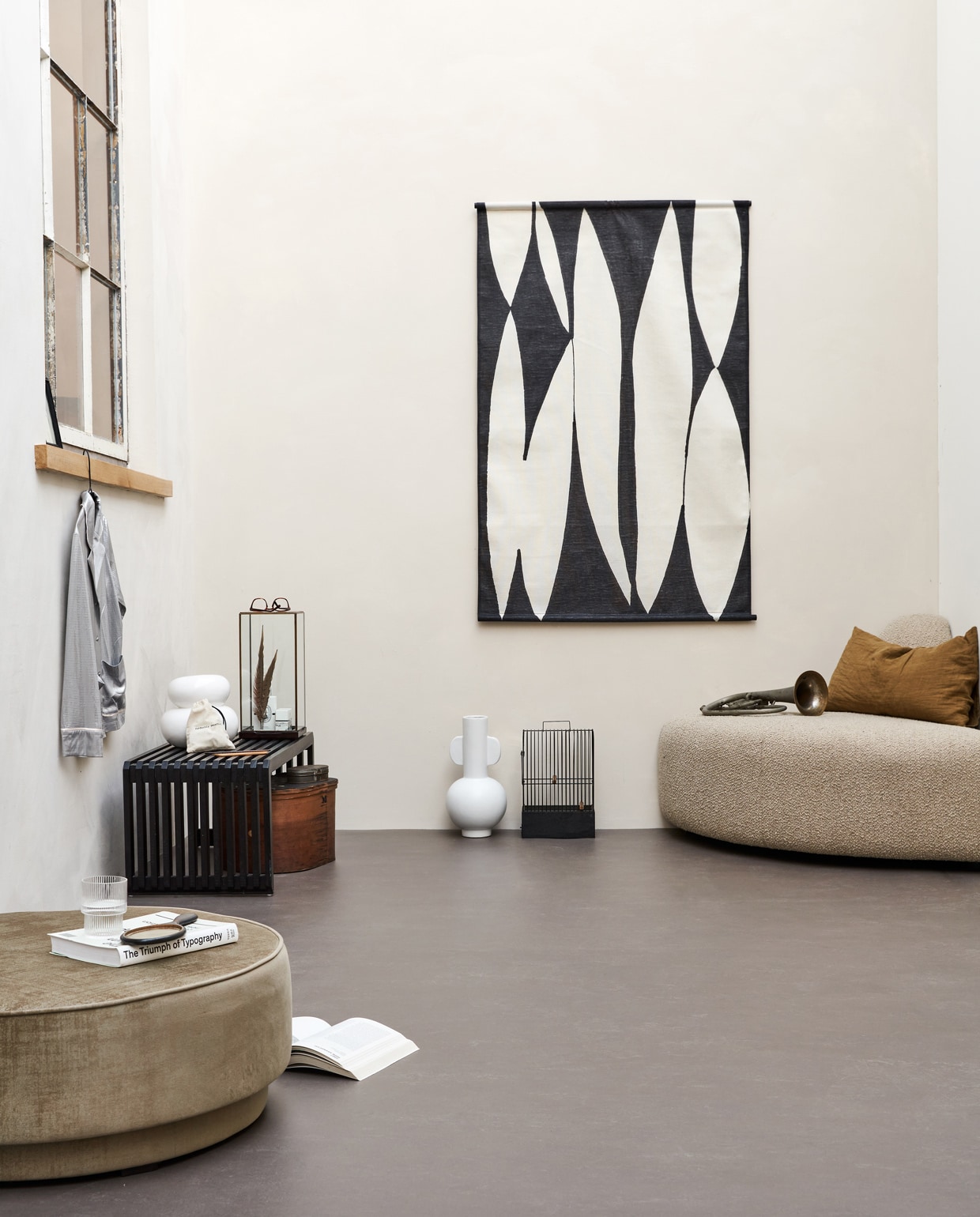 Basic woonkamer, , M.m.v. hkliving.nl (halfronde sofa, doek aan de wand, witte vaas met oren, zwarte bank, stolp van glas en hout), pantoufle-design.nl (linnen kussensloop), jolandelijkdewebshop.nl (handspiegel, vogelkooi, trompet, houten hoedendoos), vtwonen.nl (ronde poef, witte vaas met bubbels). Overig privébezit.