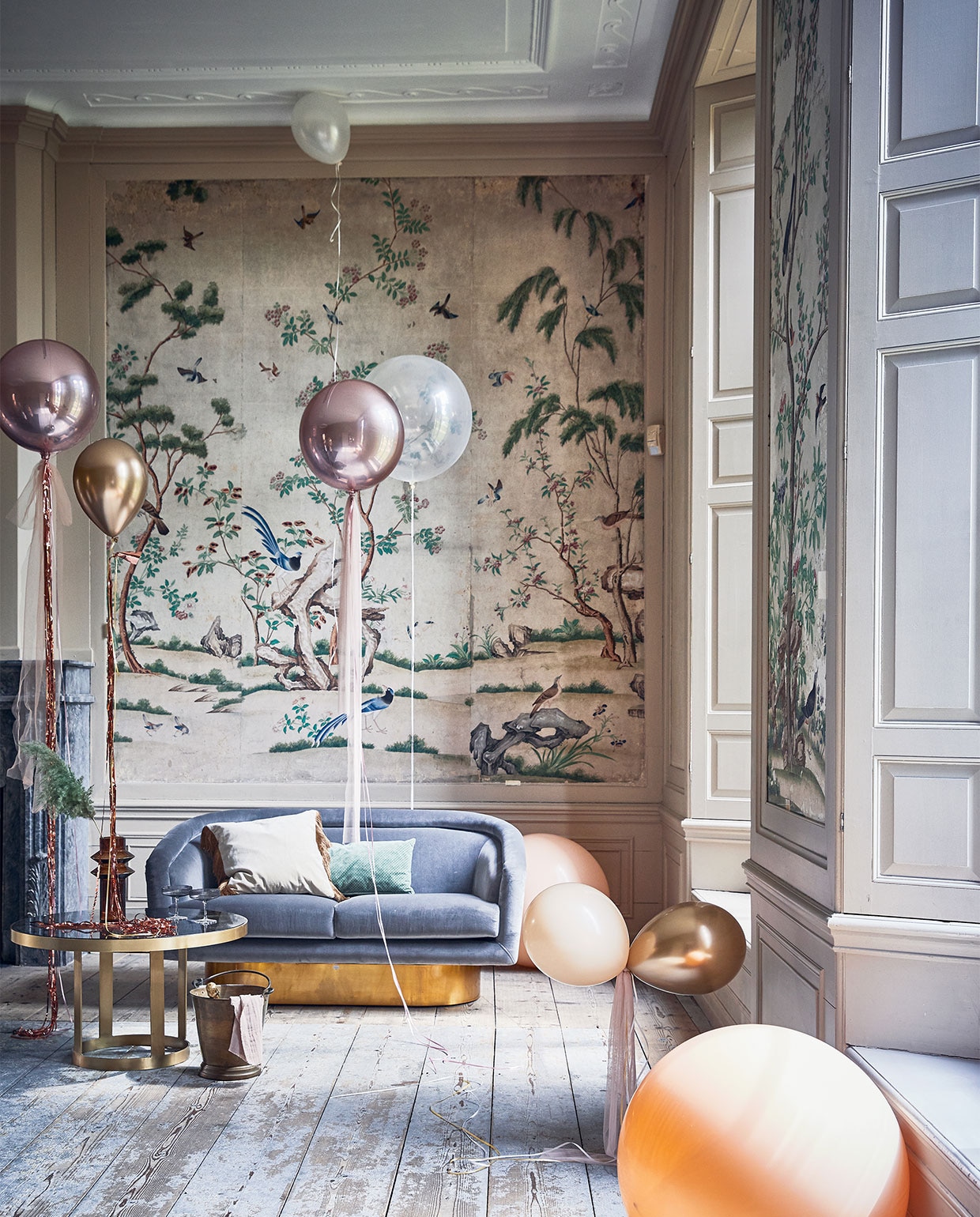Klassieke woonkamer, , Ballonnen prijs op aanvraag partyballoon.nl). Tule per meter € 5,- (boerenbonthal.nl). Franjegordijn € 9,95 (slinger.nl). Glazen salontafel 45×80 cm € 578,-, vaas € 42,50, fluwelen kussen met franjes € 46,20 (nordal.eu). Groen kussen € 34,95, grijze champagneglazen met ribbel van Ferm Living per 2 € 39,- (vtwonen.nl). Zilvergrijze fluwelen bank van Jonathan Adler vanaf € 3545,- (ankevangoor.com). Champagnekoeler prijs op aanvraag (iblaursen.dk).