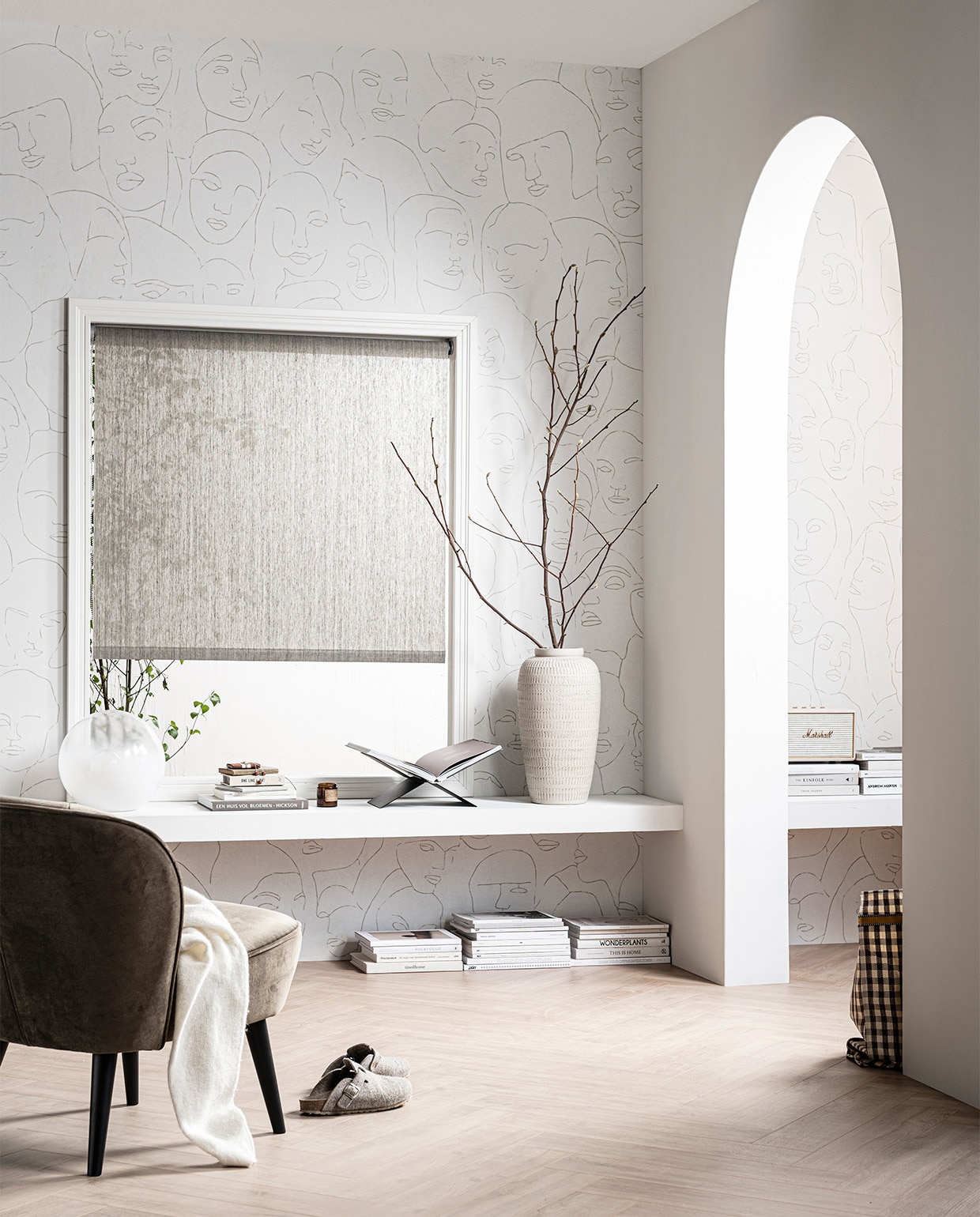 Fotobehang Faces, 3 banen van 280×50 cm, totaal 280×150 cm (hxb) € 99,-, laminaat XL visgraat Rafter naturel, inhoud per pak 1,24 m² € 29,99, verf op de muur en de boog Egg White, 1 liter € 18,95, 2,5 liter € 32,95 (mengmachine) , rolgordijn Typhoon 150×190 cm (bxh) € 97,99 (ook verkrijgbaar in breedtematen 60, 90, 120, 180 en 210 cm). M.m.v. karwei.nl (fauteuil Sarah Rib Honing , tafellamp, glas), mendo.nl (boekenstandaard). Overig privébezit.