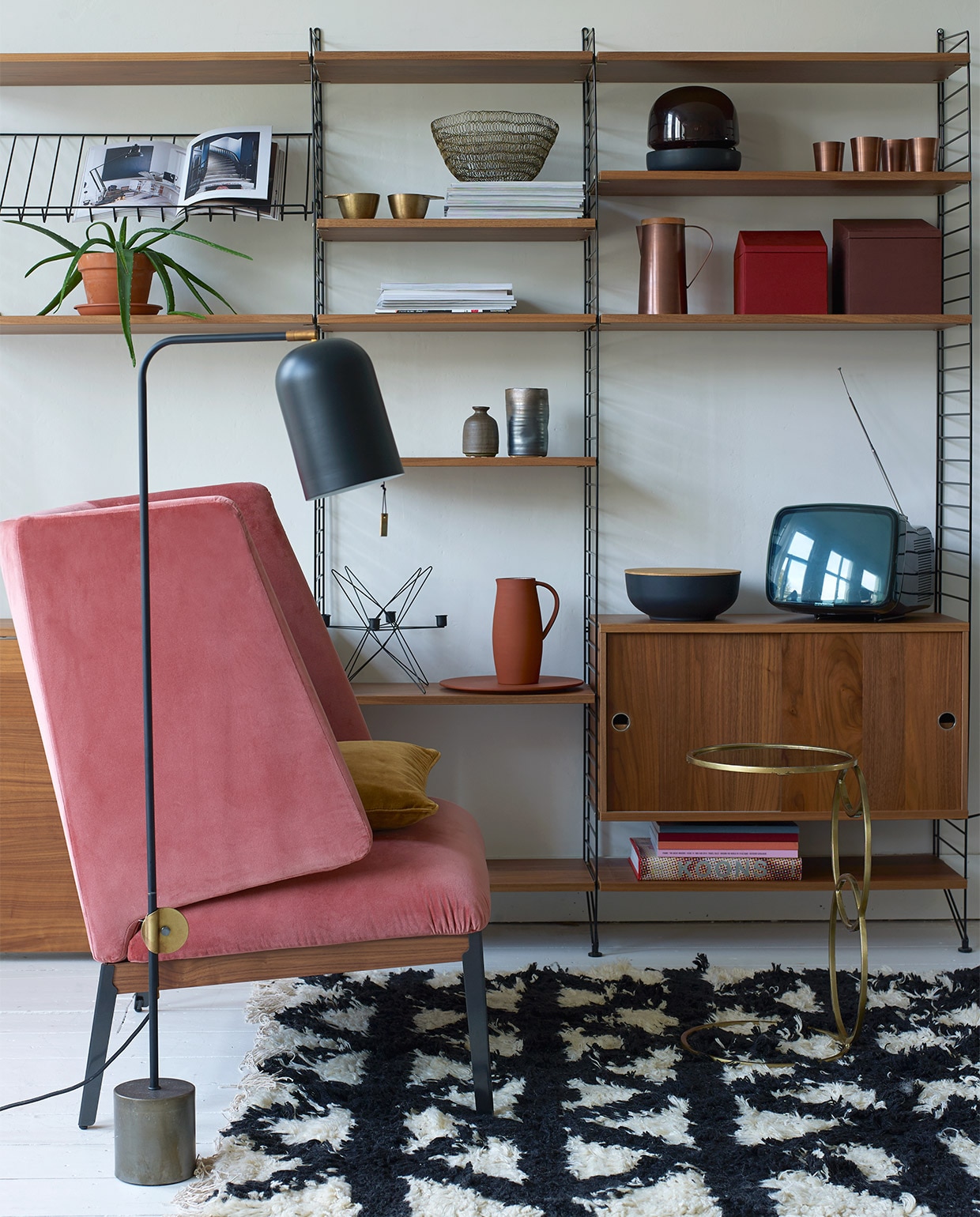 Lounge chair Hug van Arflex, zithoogte 44 cm, rughoogte 103 cm € 2704,-, kast String in uitvoering 200x215x30 cm (hxbxd) € 1988,-, vloerlamp € 586,- (Mobilia). Wollen vloerkleed Indochine Nights, 140×200 cm € 419,- (Aai Made with Love). Bijzettafel van Madam Stoltz € 145,- (deens.nl). In de kast: Kandelaar in stervorm van ijzerdraad € 31,-, schaal van ijzerdraad € 27,50, zwarte schaal met deksel € 36,50, vaasjes van Madam Stoltz vanaf € 6,95 (deens.nl). Koperen kan met houten deksel € 49,95, koperen bekers € 8,95, messing bekers € 15,95 (Nijhof). Glazen lamp van Menu € 229,95, terra kan en schaal van SCP € 139,-, rode en bruine dozen van Menu, per set van 3 stuks € 69,95 (Mobilia).