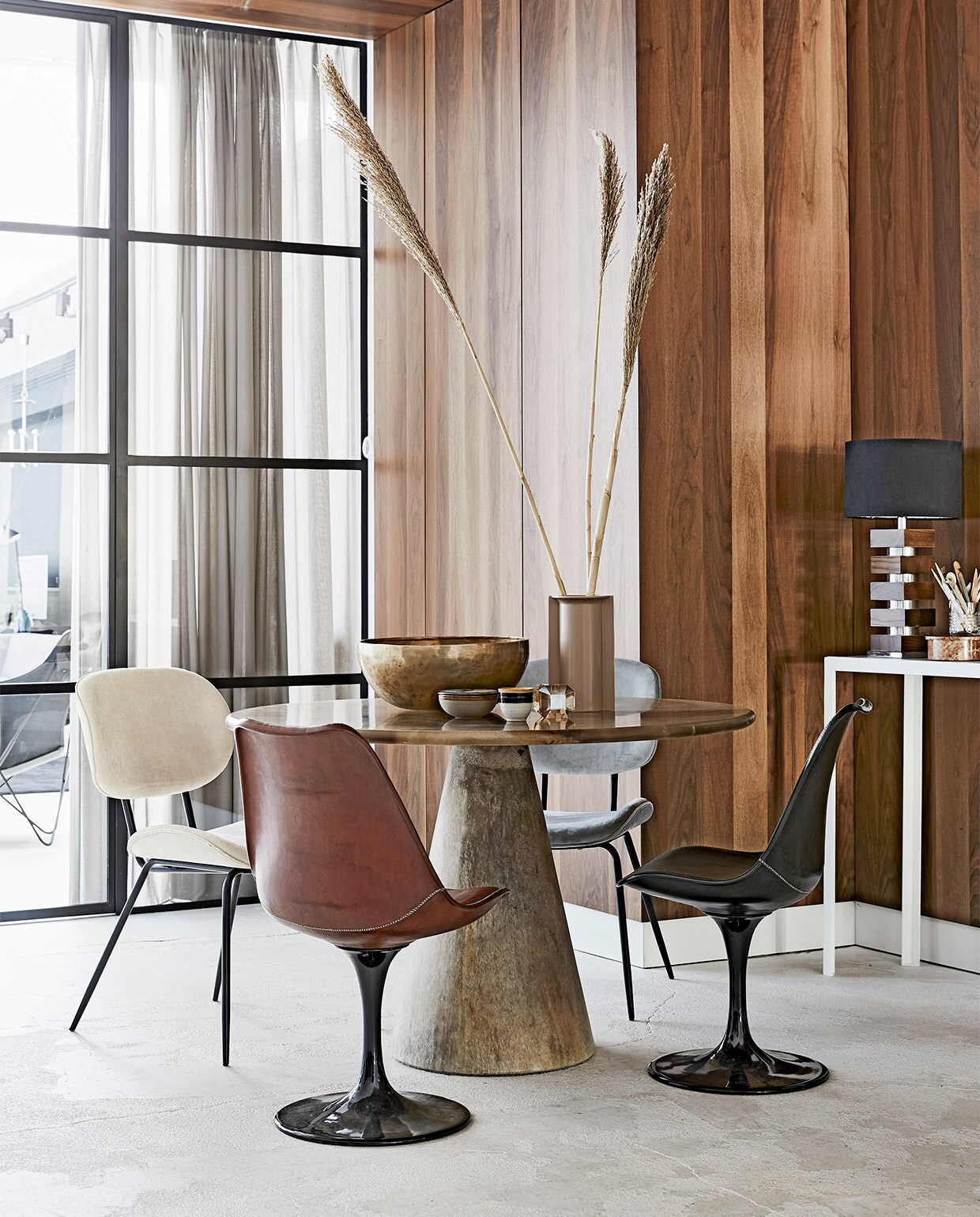 Wandbekleding en interieur-ontwerp door Sander van Eyck (cocoon-living.nl). Ronde tafel Meltingpot in kleur goldstone, Ø 120 cm € 2450,- (Dirk Vander Kooij). Leren kuipstoelen vanaf € 695,- (Brecht Murré Atelier). Fluwelen stoelen € 165,-, nudekleurige vaas € 29,95, kopje set van 2 € 9,90, glazen kandelaar € 49,95 (HK Living). Bronzen schaal, Ø 39 cm € 340,- (X + L). Vintage lamp en sidetable Consoletable Artemis by Sander van Eyck, prijzen op aanvraag, schaaltje met deksel € 30,- (cocooncollectables.nl). Marmeren bakje met deksel € 89,-(MaisonNL).