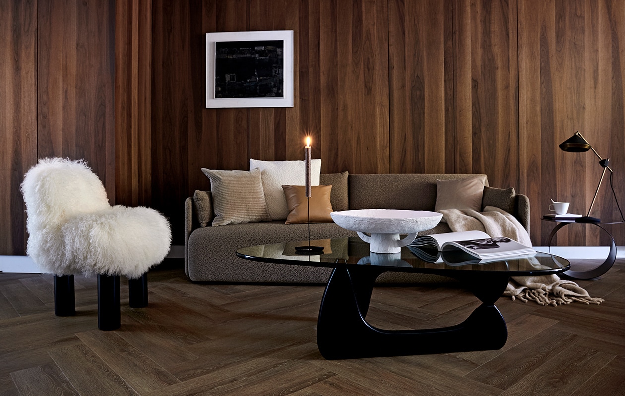 Vloer uit de vtwonen collectie: PVC Vloer Herringbone Roasted, 76,5×15,3 cm per m² € 44,95 / € 57,95 (resp. dryback-systeem / click-systeem), ook in kleuren Natural, Sun Kissed en Polar.M.m.v. designtales.nl (bank), covanderhorst.nl (salontafel, fauteuil, bouclé kussen, velours kussen, tafellamp), kasstoor.nl (bijzettafel rond), klevering.nl (witte schaal, kandelaar, mok), bolia.com (velours kussen, leren kussen), loods5.nl (plaid), cocoon-living.nl (kunst). Overig privébezit.