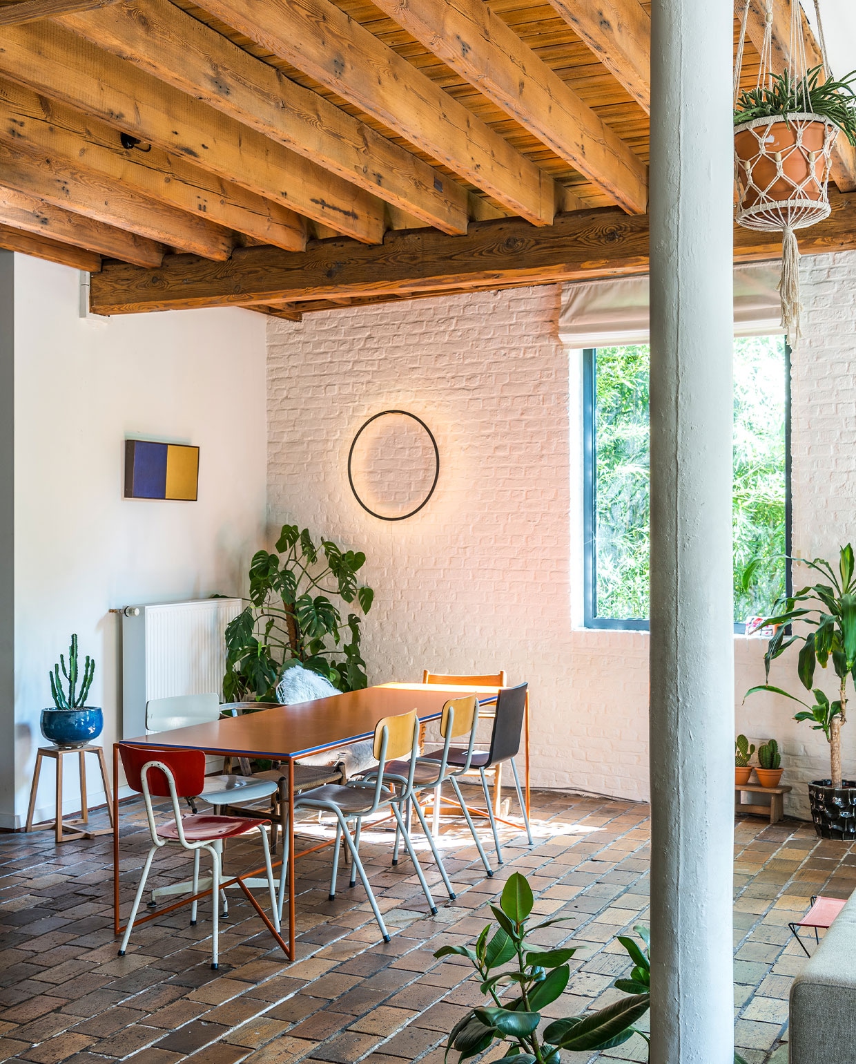 Schilderij Russell Scarpulla, kruk en tafel Piece van Maria Scarpulla, lamp Eclipse van Tilen Sepic, schoolstoelen en draaistoel straatvondst. Andere stoelen Vitra .03 van Maarten Van Severen, Wishbone Chair van Hans Wegner en Bertoia Side Chair van Harry Bertoia voor Knoll. Kop Kolonel leger, theepot Bornn Enamelware, vaas erfstuk grootmoeder.
