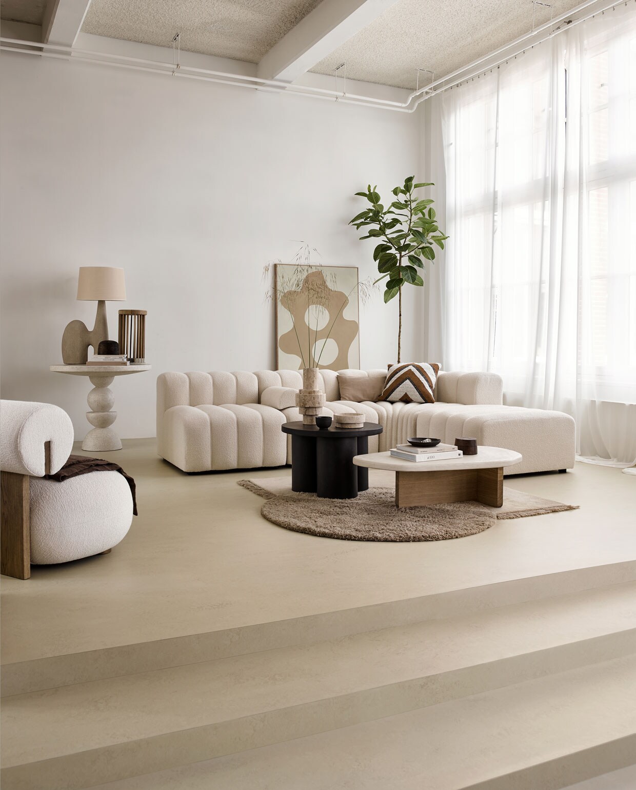 Marmoleum vloer kleur Zand, per m² € 48M.m.v. norr11.com (bank), fermliving.com (kleed), bondinterior.nl (fauteuil van Norr11), anneoldekalter.com (schilderij), aedamanthony.nl (salontafel met microcement blad en houten onderstel), edha-interieur.nl (donkerbruine salontafel van 101 Copenhagen, kussen met strepen), domedeco.com (travertin vaas en schaal), lanena-home.com (lamp, witte hoge tafel), prinsheerlijkantiek.nl (houten hoedenmallen), studiomilo.nl (houten object met beton). Overig privébezit.